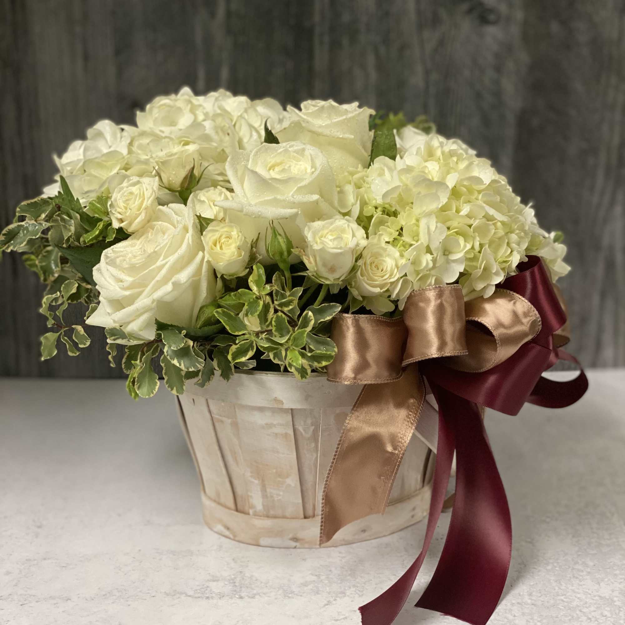 White or Yellow roses, mini carnations, hydrangeas and elegant filler gracing a