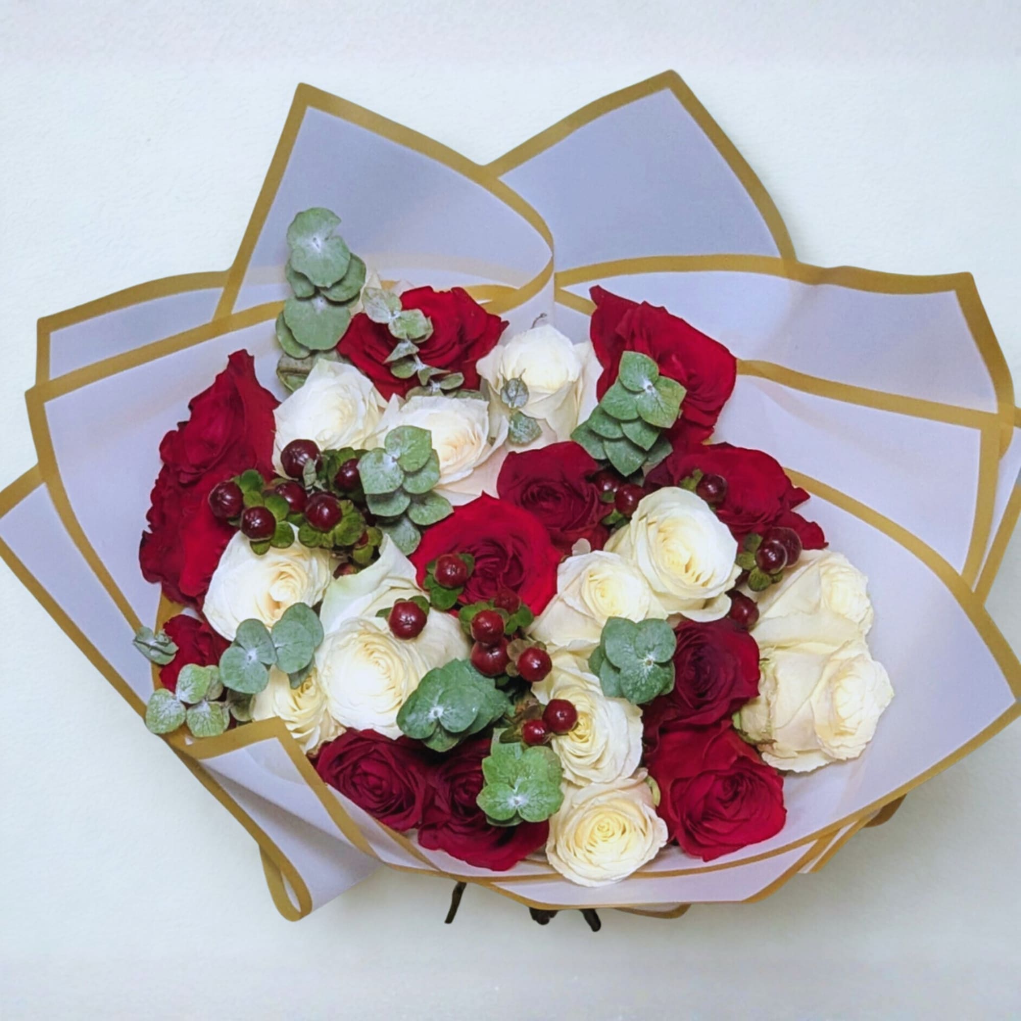 A beautiful hand-tied bouquet featuring 24 premium red and white roses, accented