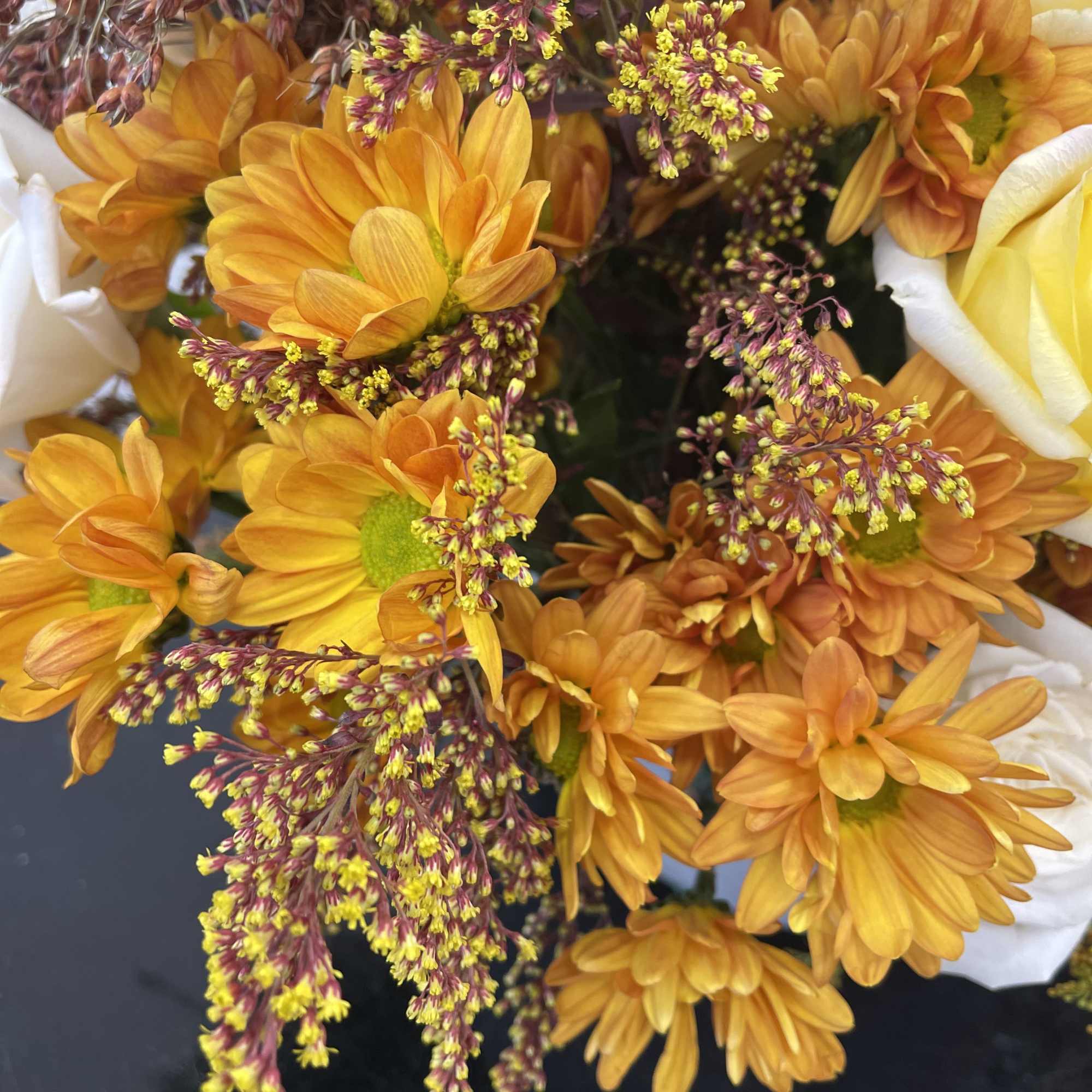 A vibrant mix of autumn hues, featuring yellow and orange blooms accented