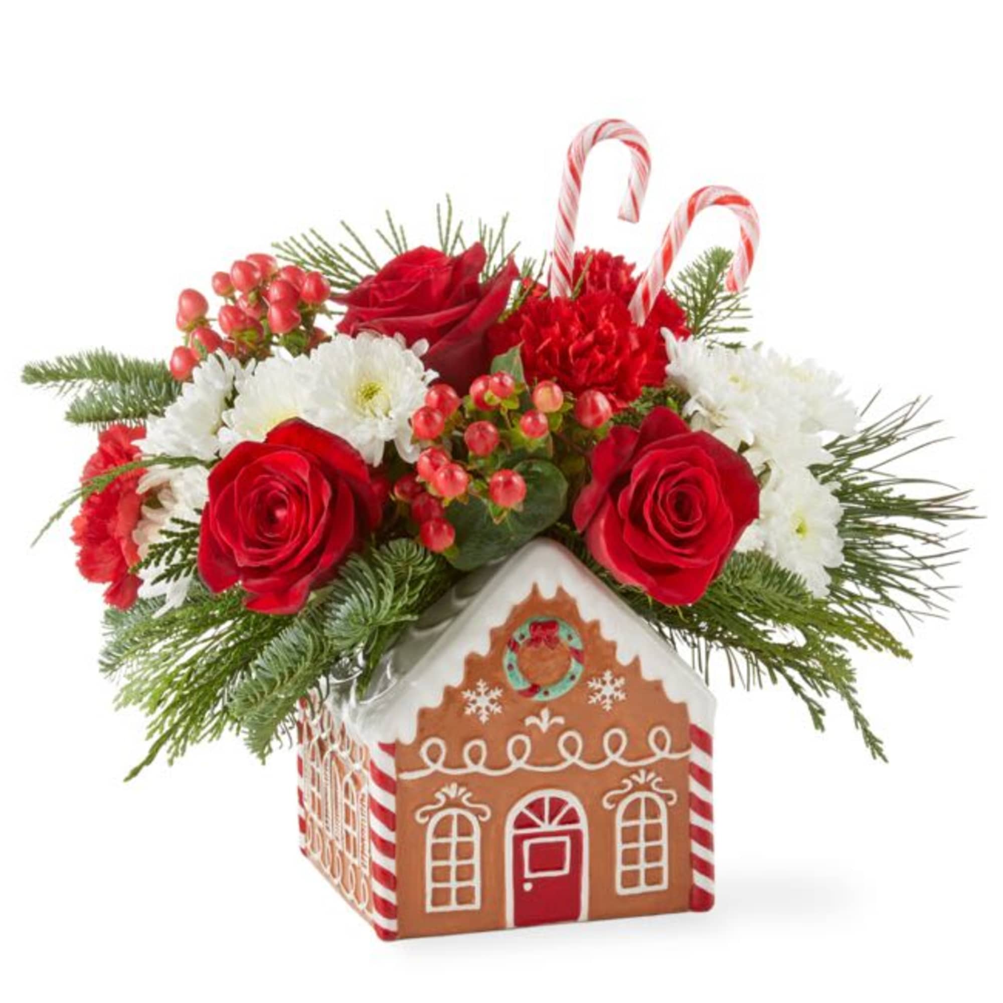 Filled with fresh winter pine and rich roses, this gingerbread house arrangement
