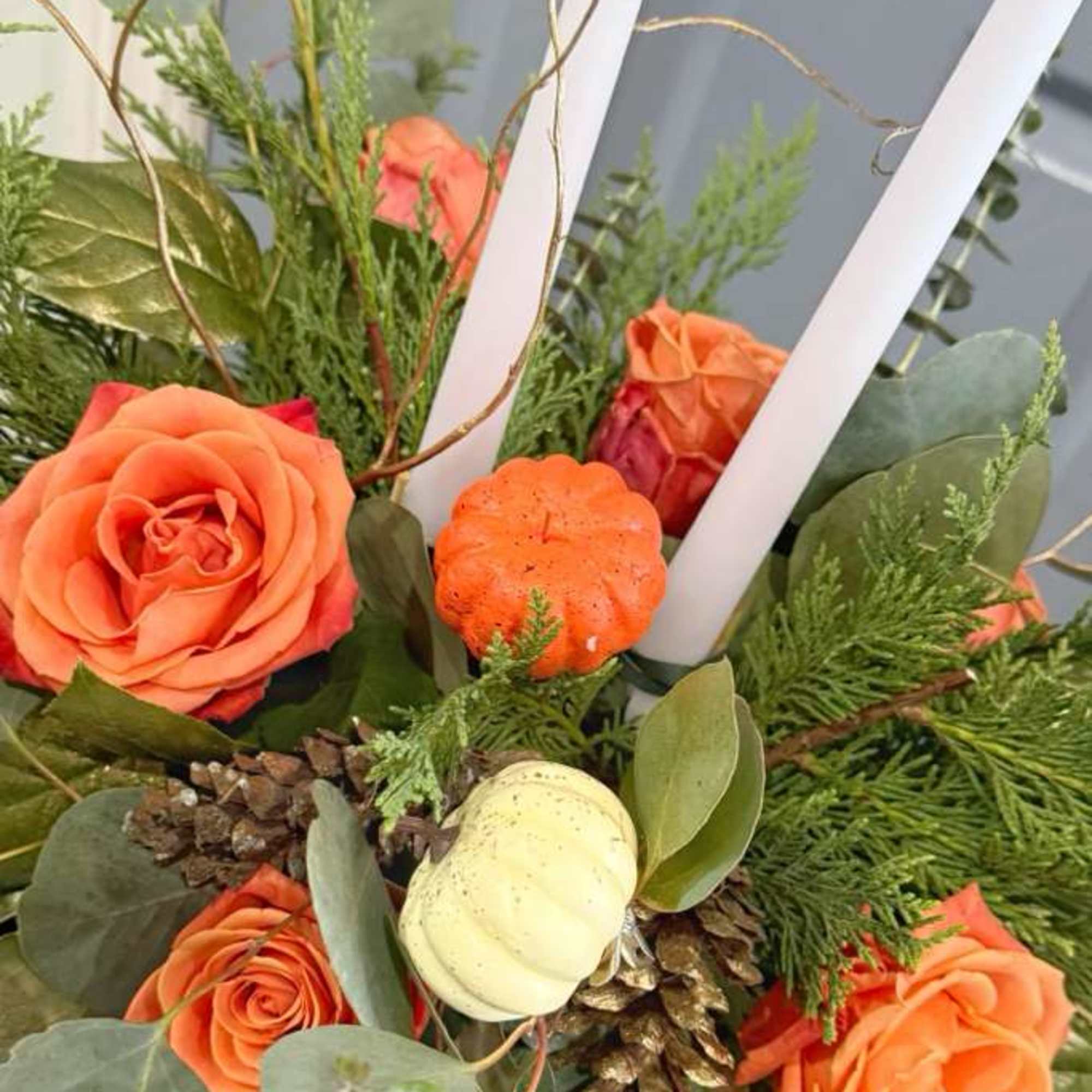 Centerpiece with seasonal roses and artificial pumpkins, two centerpiece candles that will