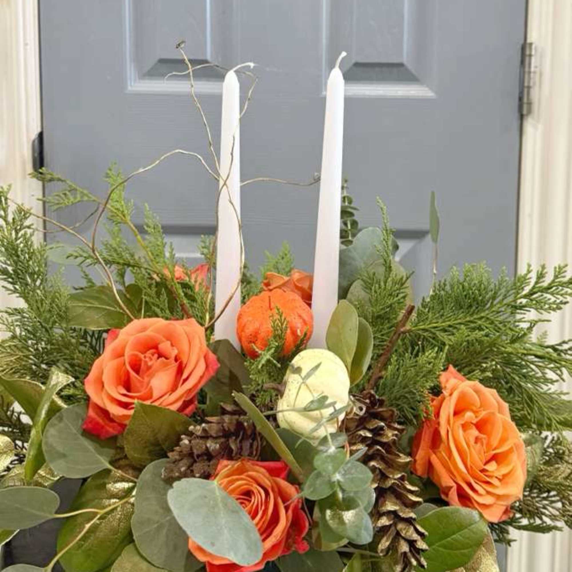 Centerpiece with seasonal roses and artificial pumpkins, two centerpiece candles that will