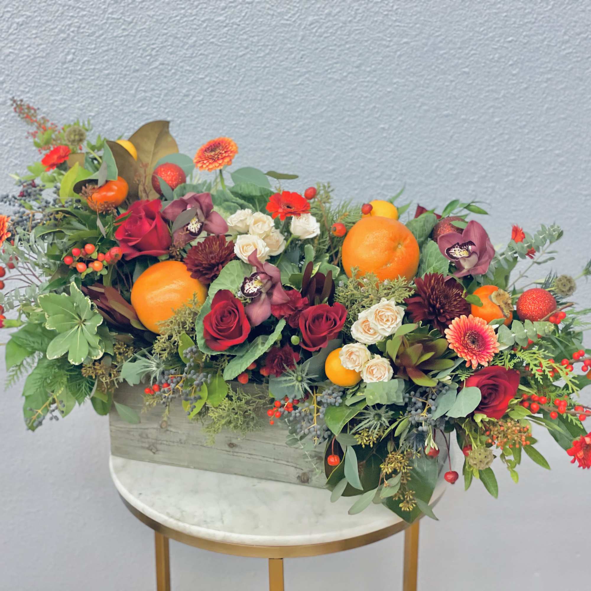 Holiday joy in a box!  Red roses, festive berries, persimmons, grapefruit