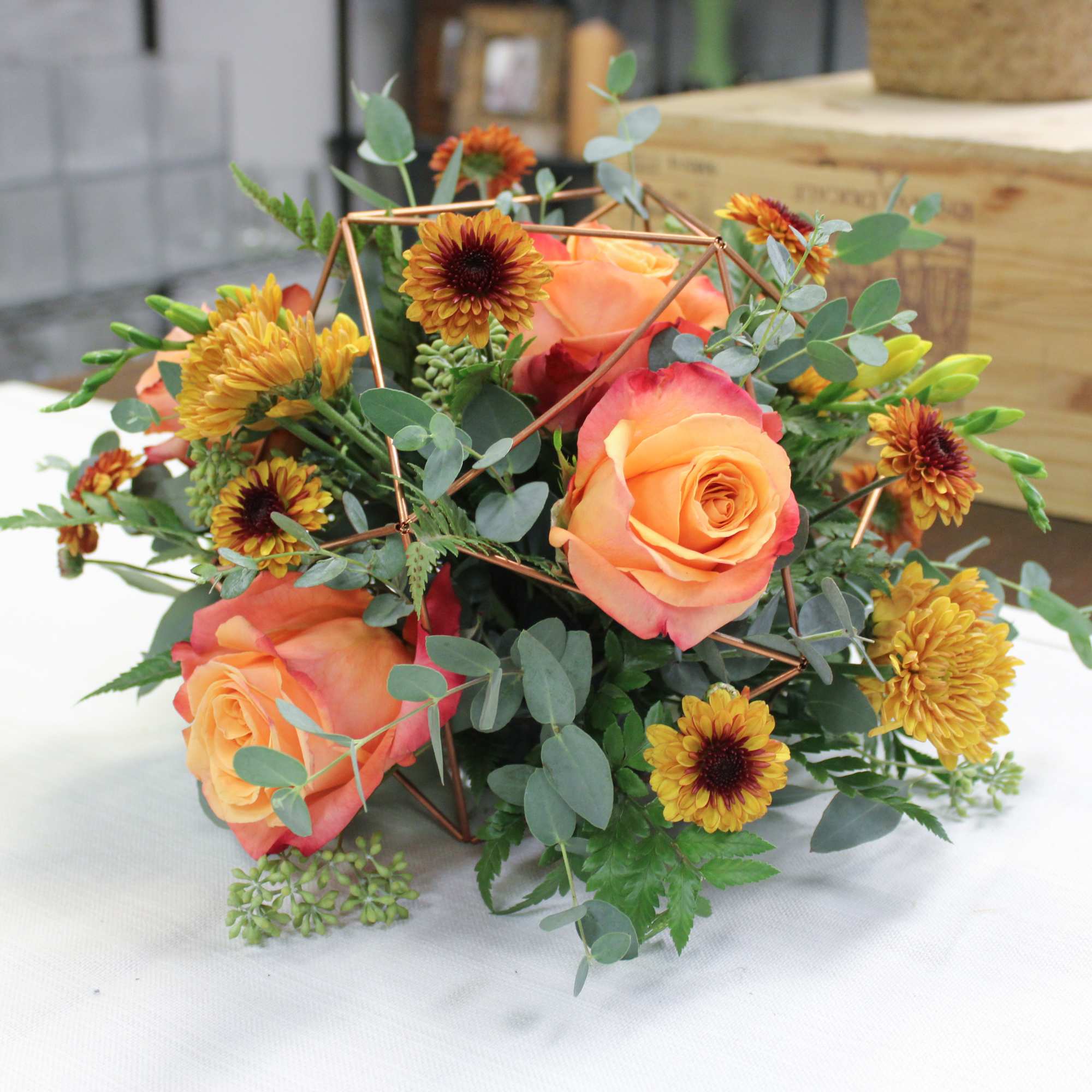 Clementine is a fun centerpiece arrangement designed in a rose gold keepsake