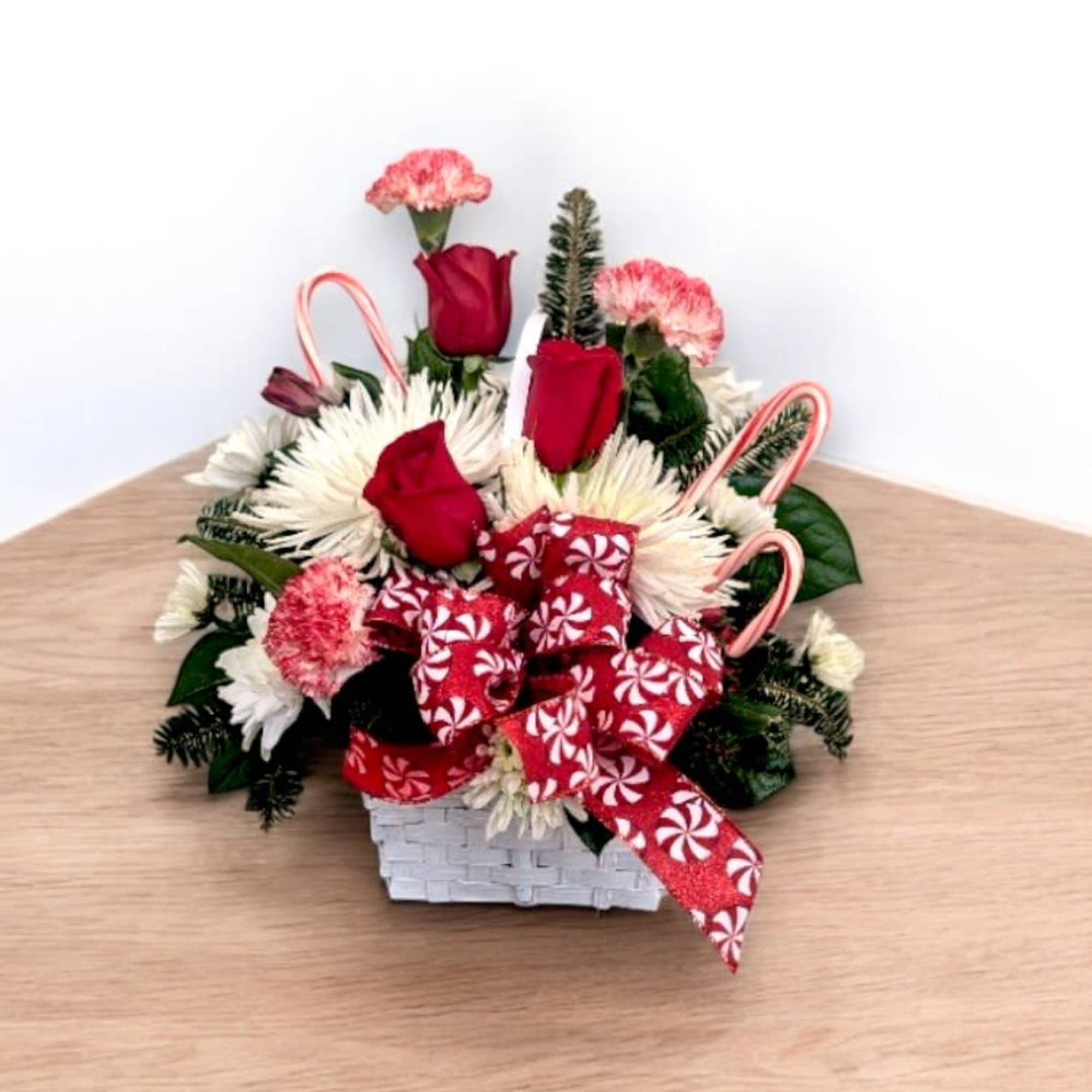 A cheerful holiday design in a basket with red and white flowers