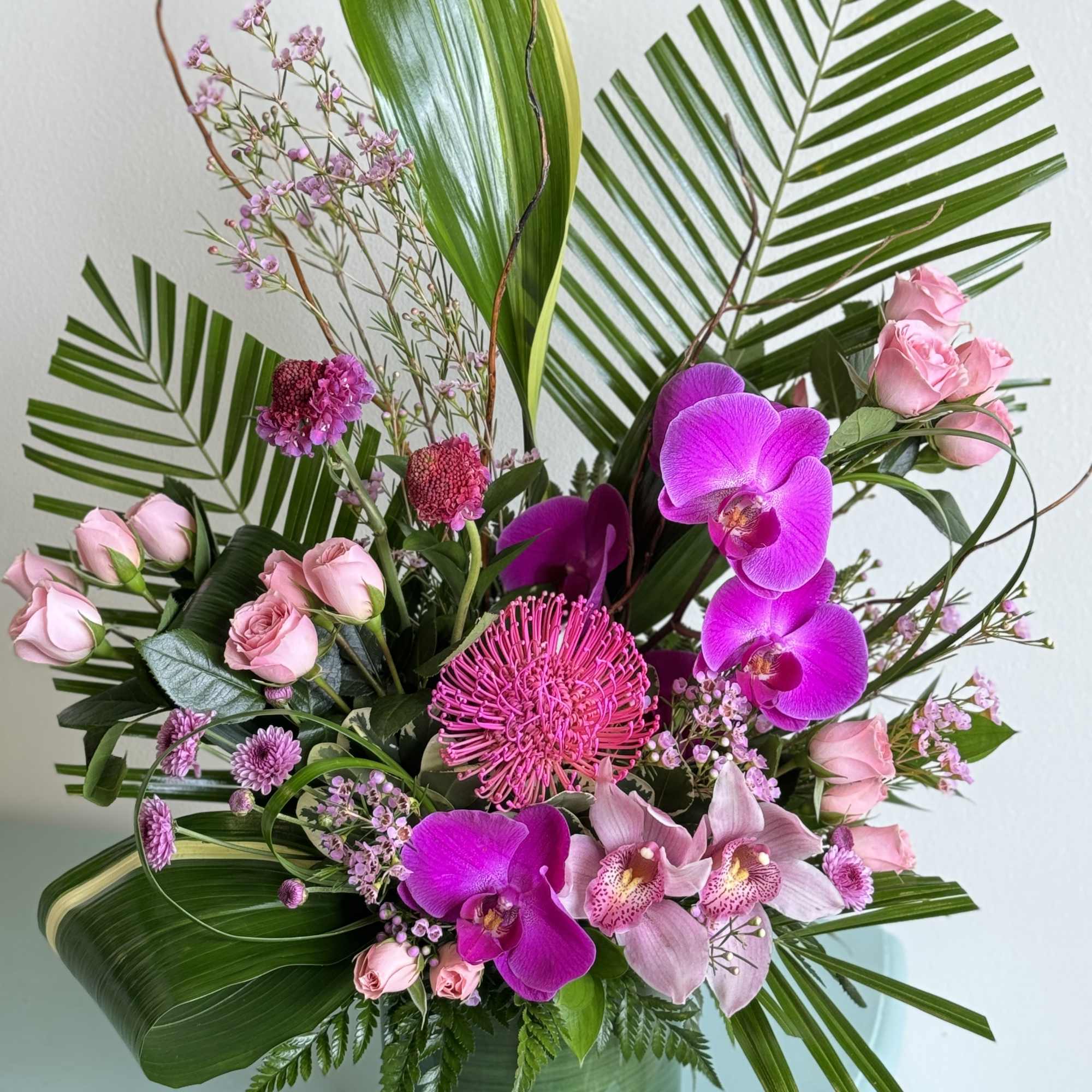 A gorgeous arrangement of tropical stems. Colors are customizable. Please call in