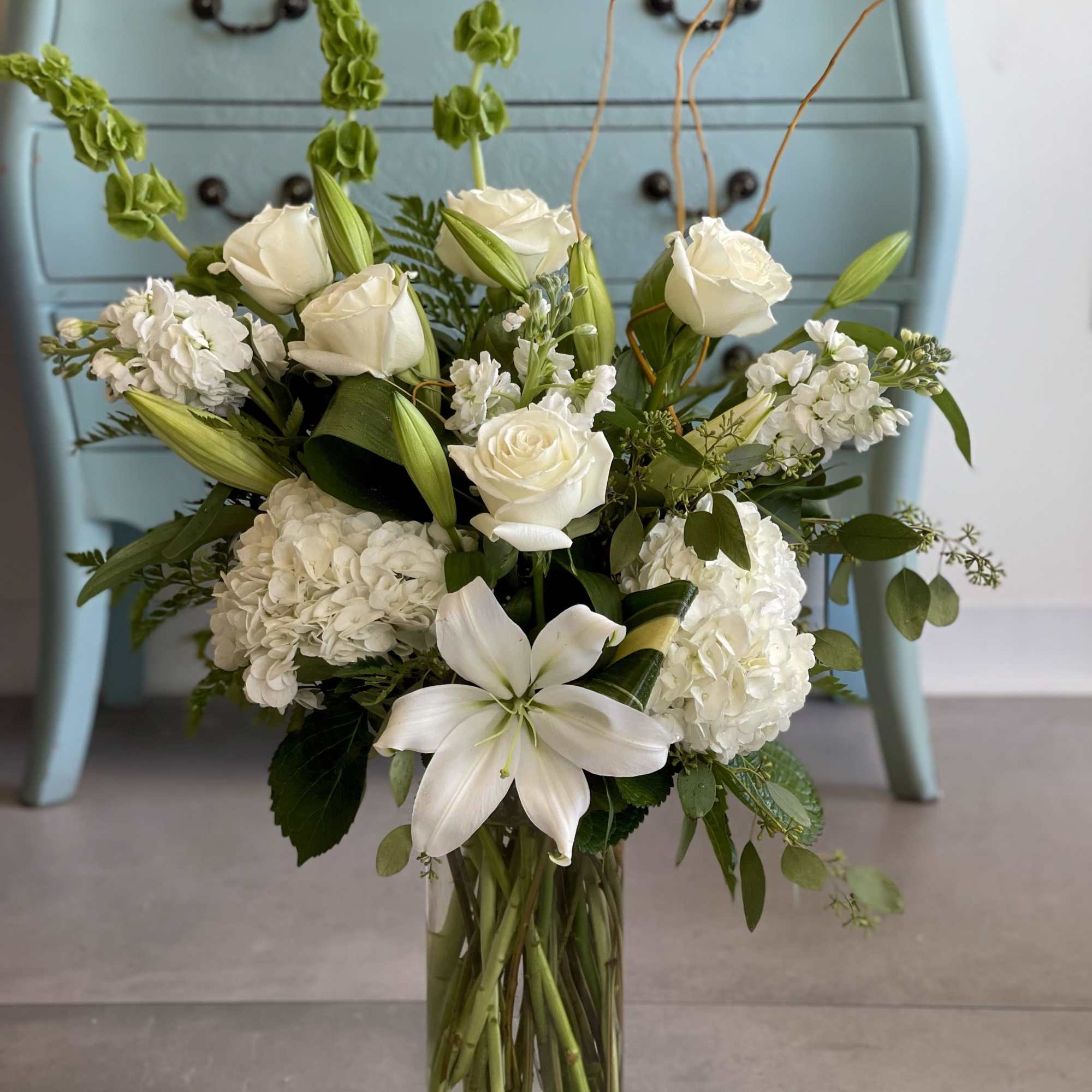 An elegant arrangement of white lilies, stunning hydrangea,  white roses and