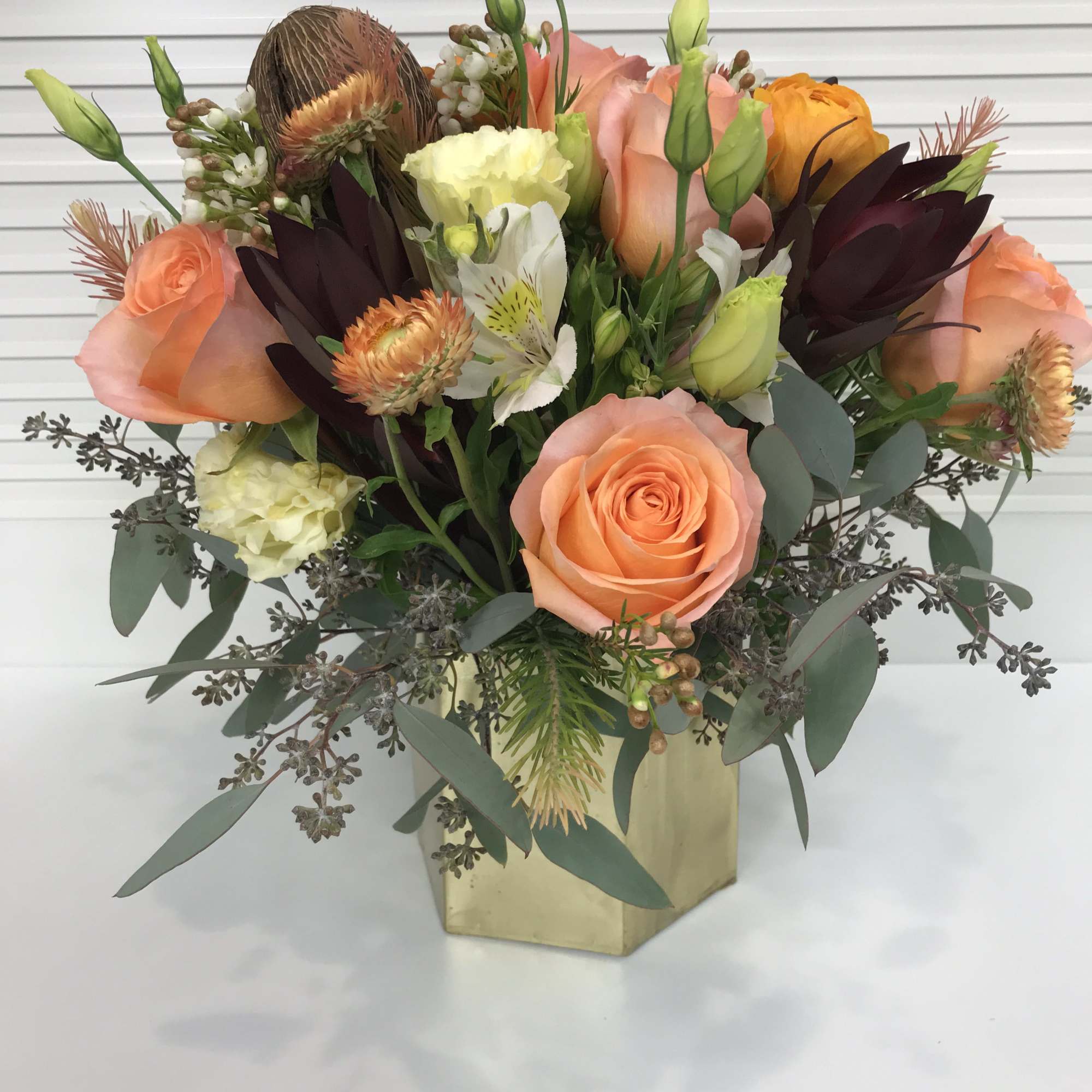 Collection of peach colored roses, ranunculus. salary, alstroemeria, Lisianthus, wax flowers, and