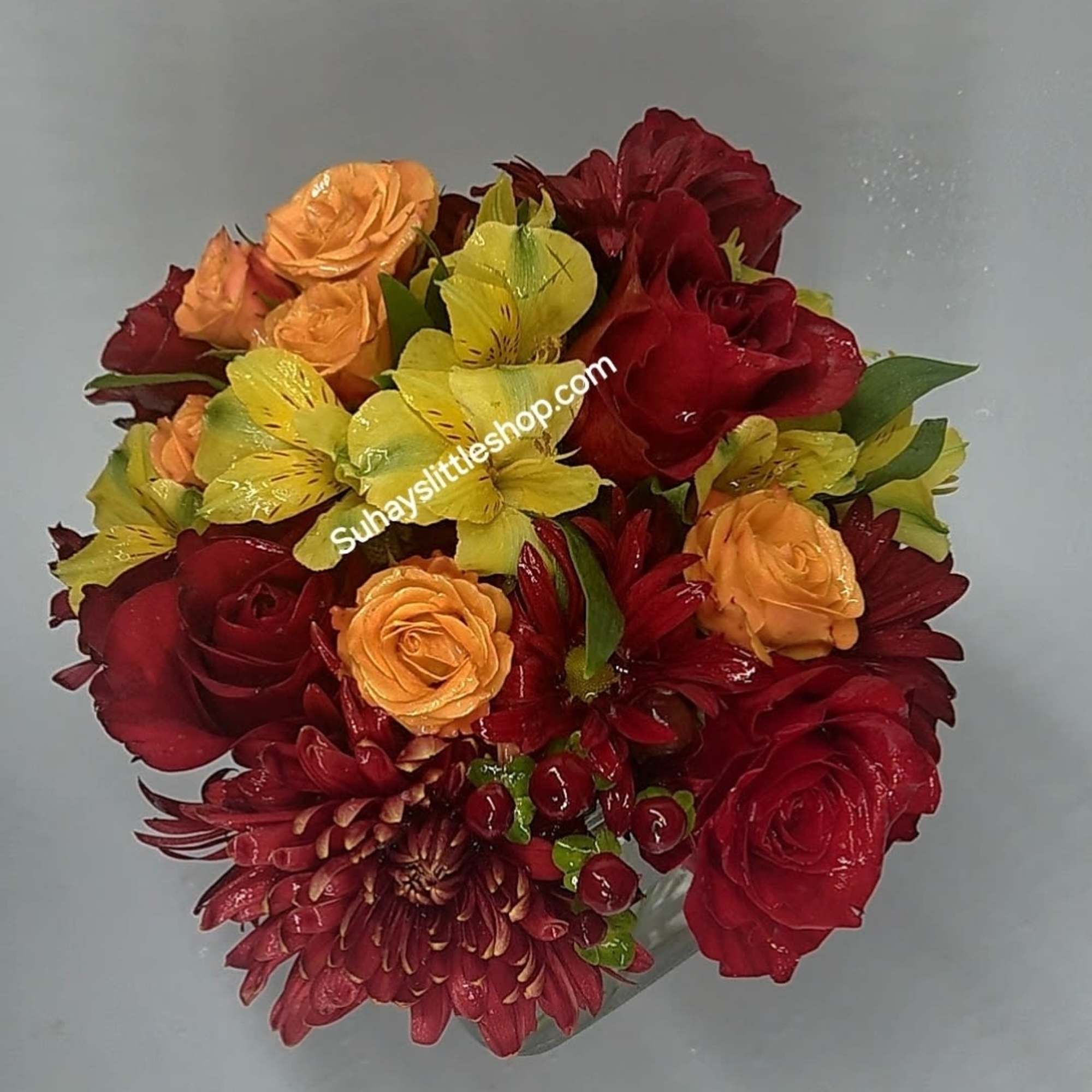 A lovely arrangement of red and orange roses mixed with delicate alstroemeria