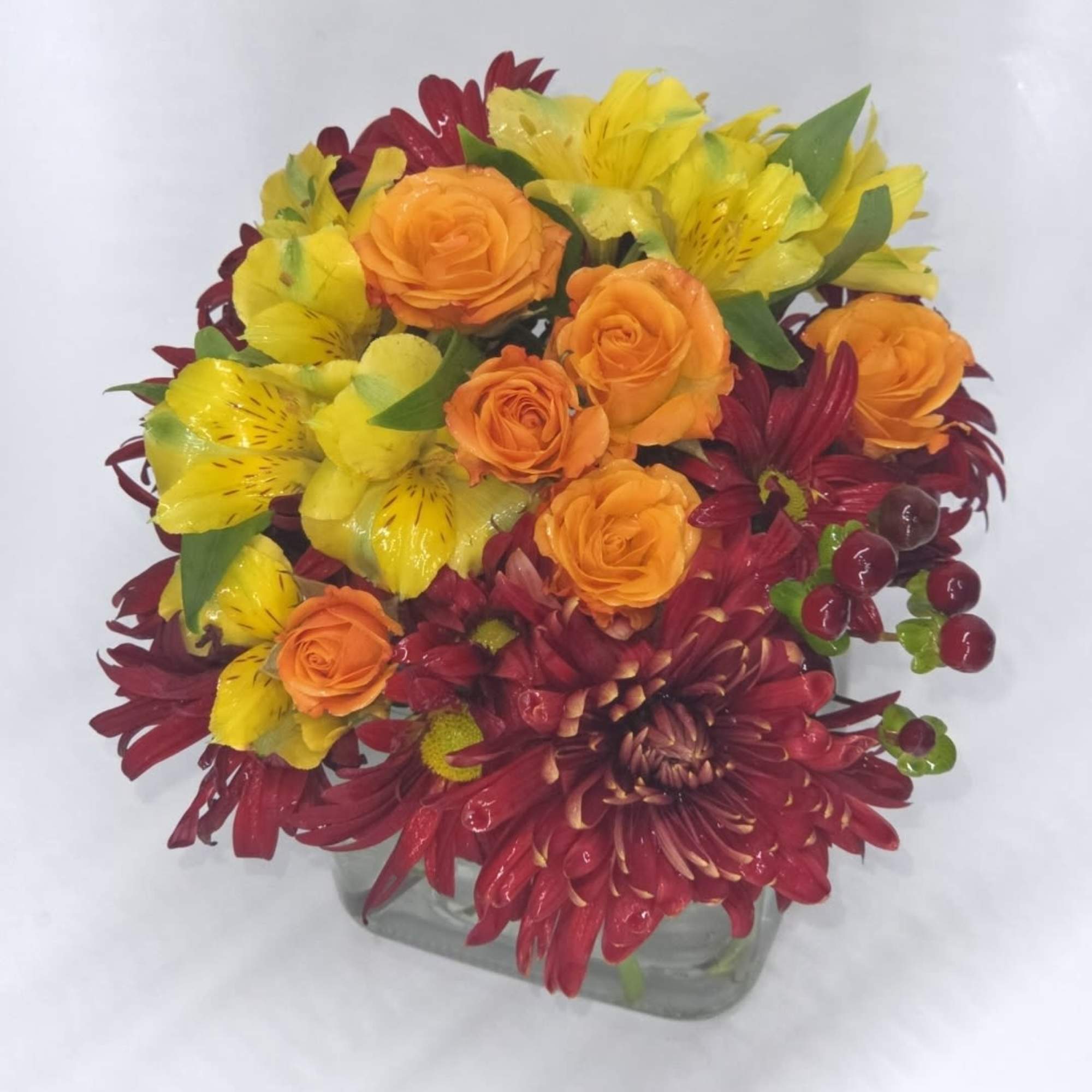 A lovely arrangement of red and orange roses mixed with delicate alstroemeria