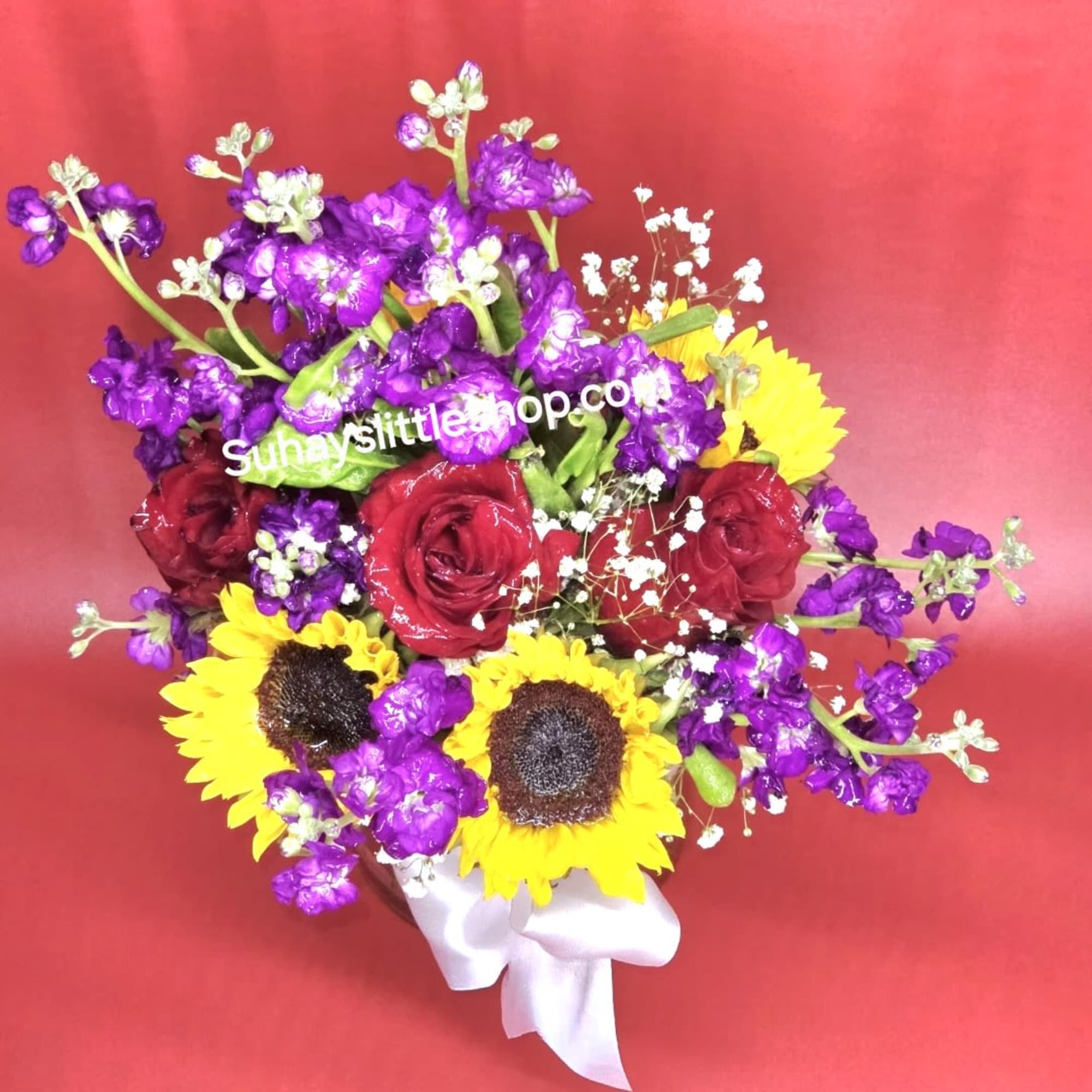 Romantic fall mood floral arrangement featuring purple-red sunflowers and warm autumn lighting.
