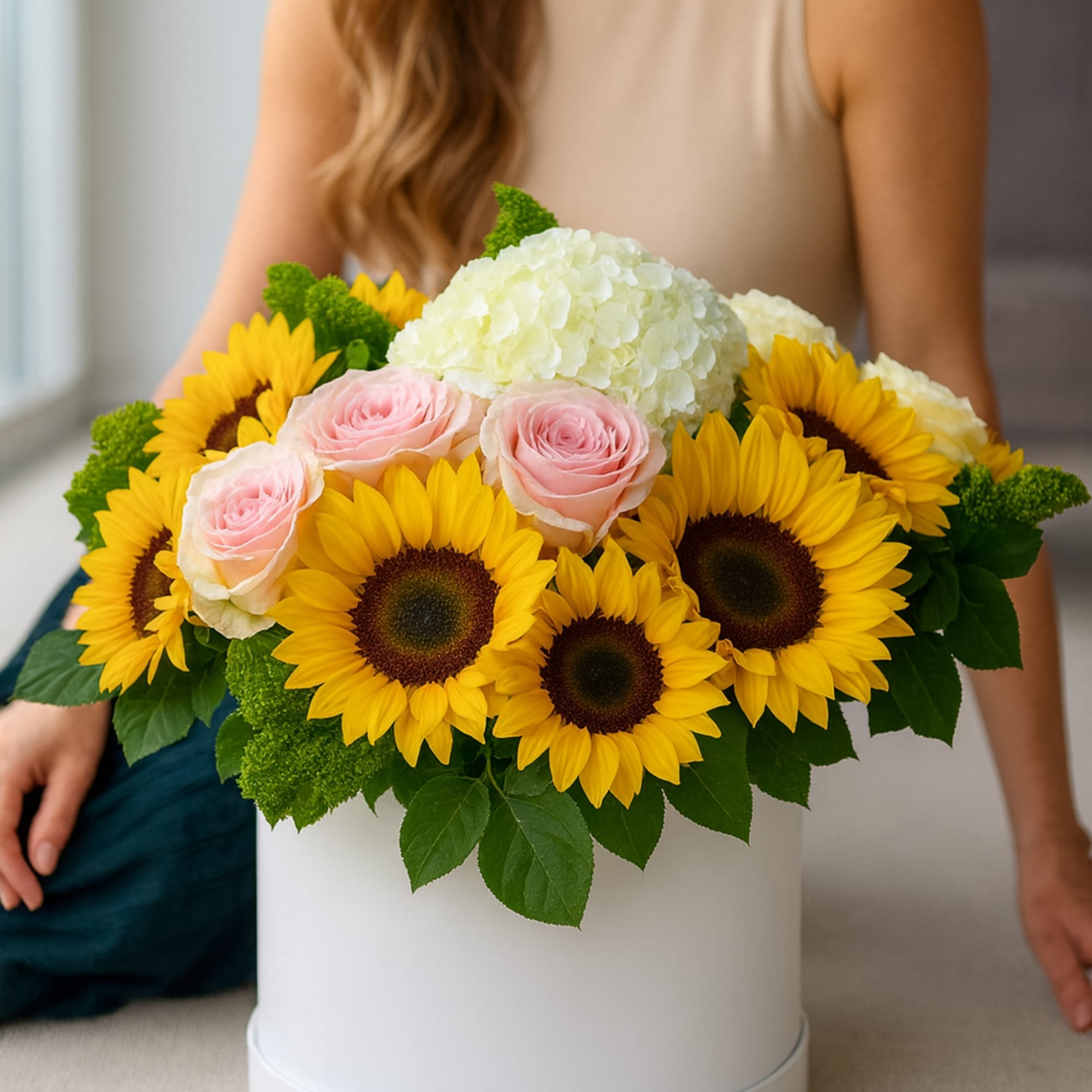 A Round box arrangement of hydrangeas, roses, and sunflowers. How can something