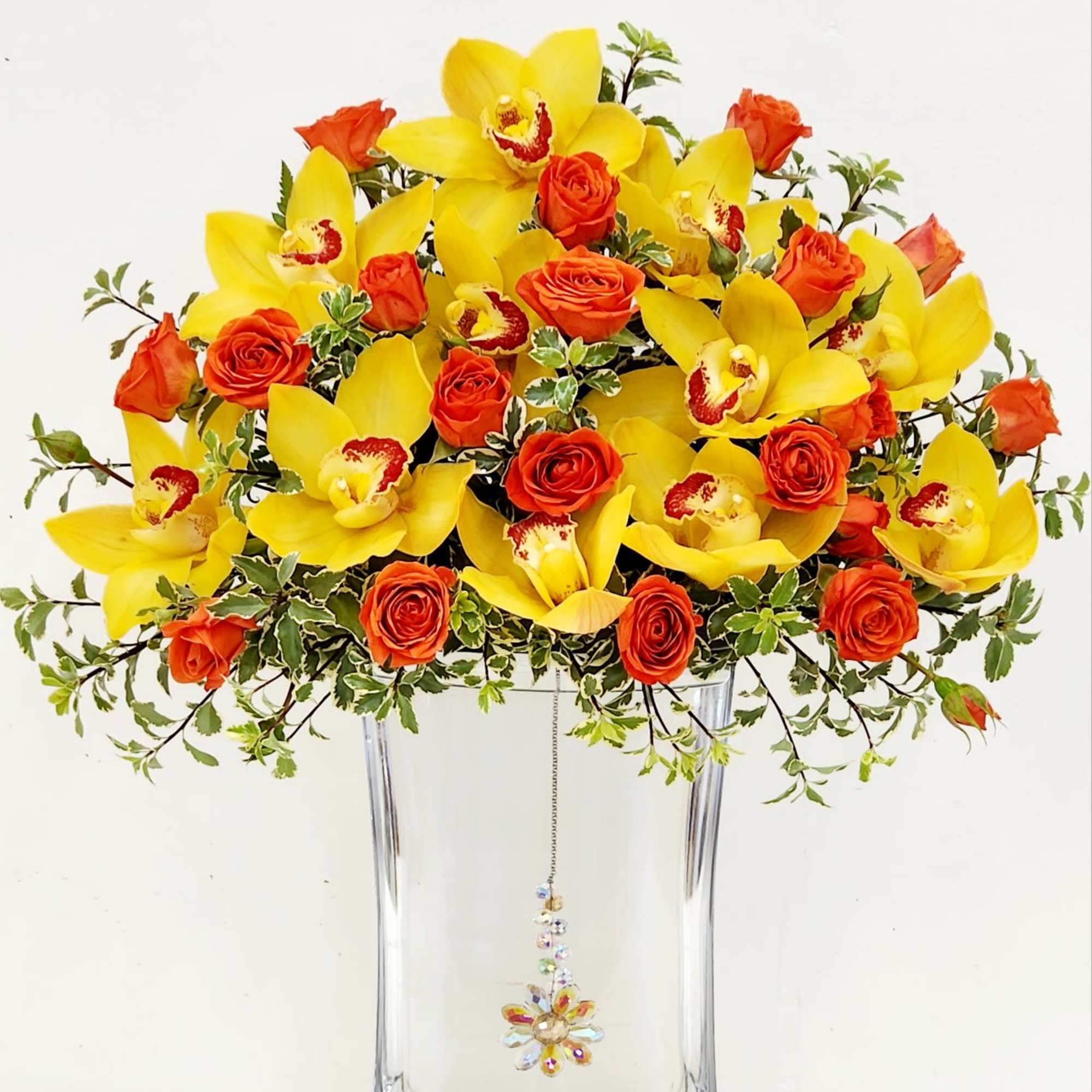 A stunning display of yellow orchids and orange spray roses, artfully floating