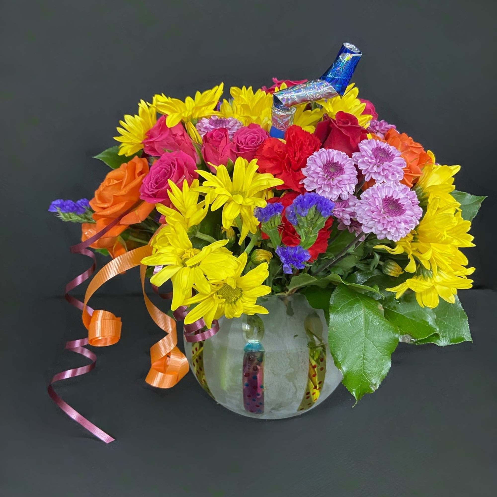 A frosted globe is decorated with birthday candles and filled with seasonal