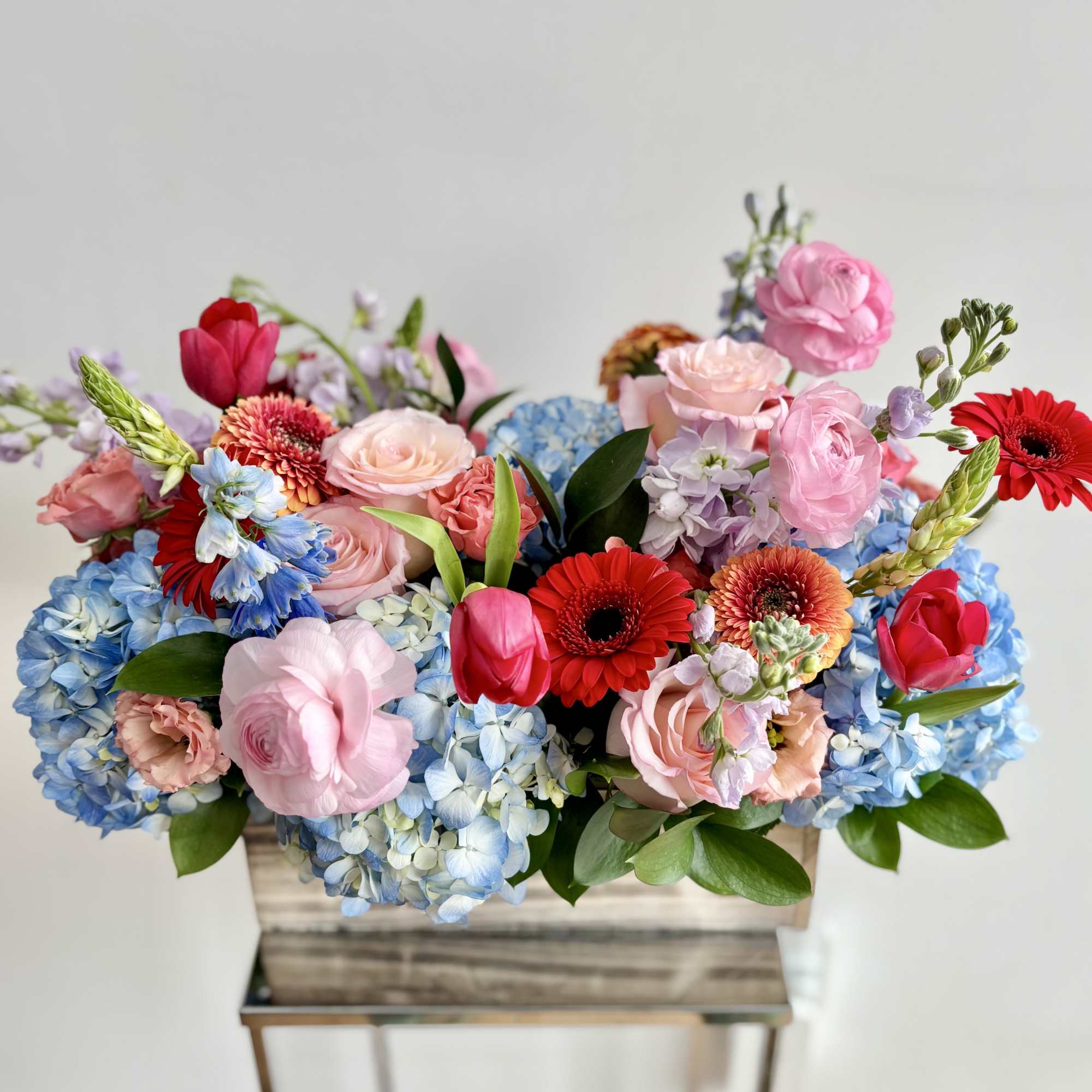 A rich mix of seasonal flowers in variety of bright colors arranged