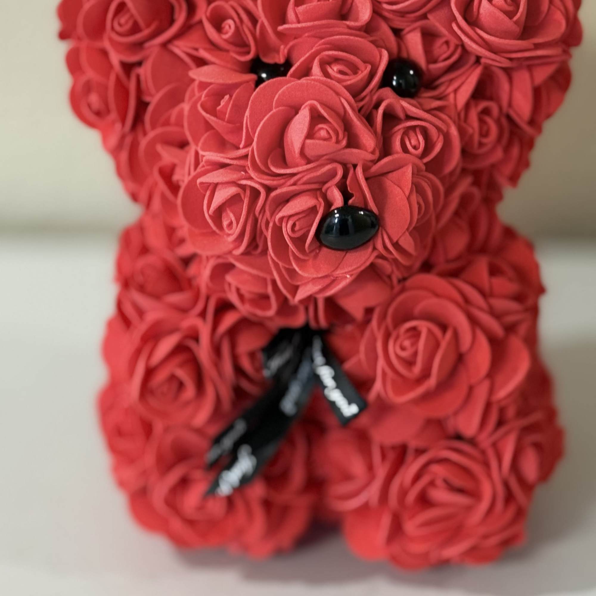 A luxury bear made with faux rose blooms in shades of red
