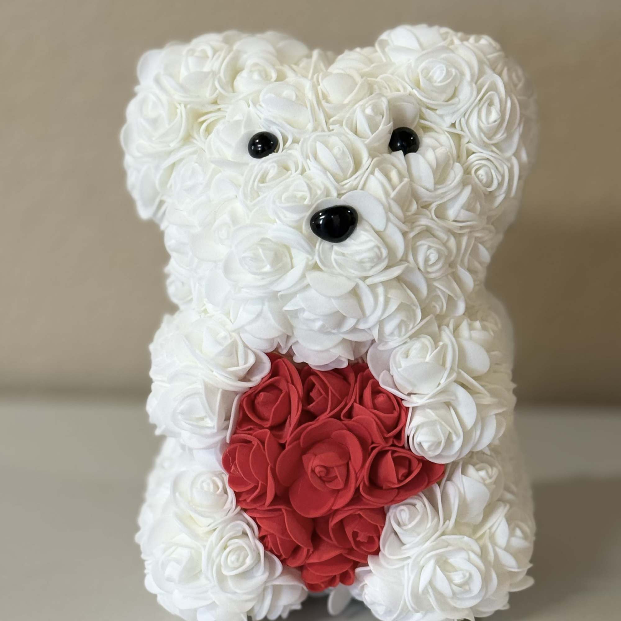 A luxury bear made with faux rose blooms in shades of red