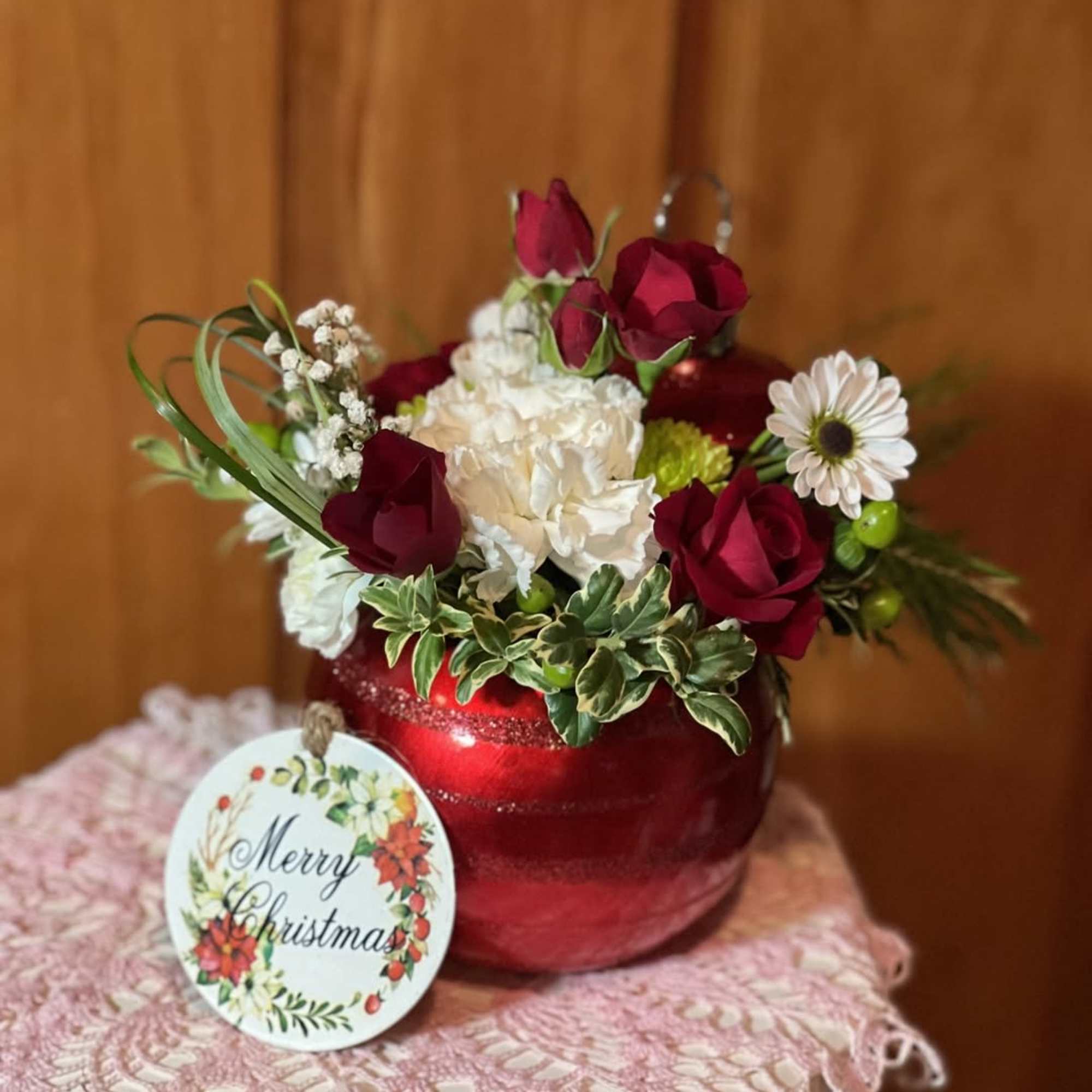 Florist Choice of either silver, red or green ornament. Filled with the