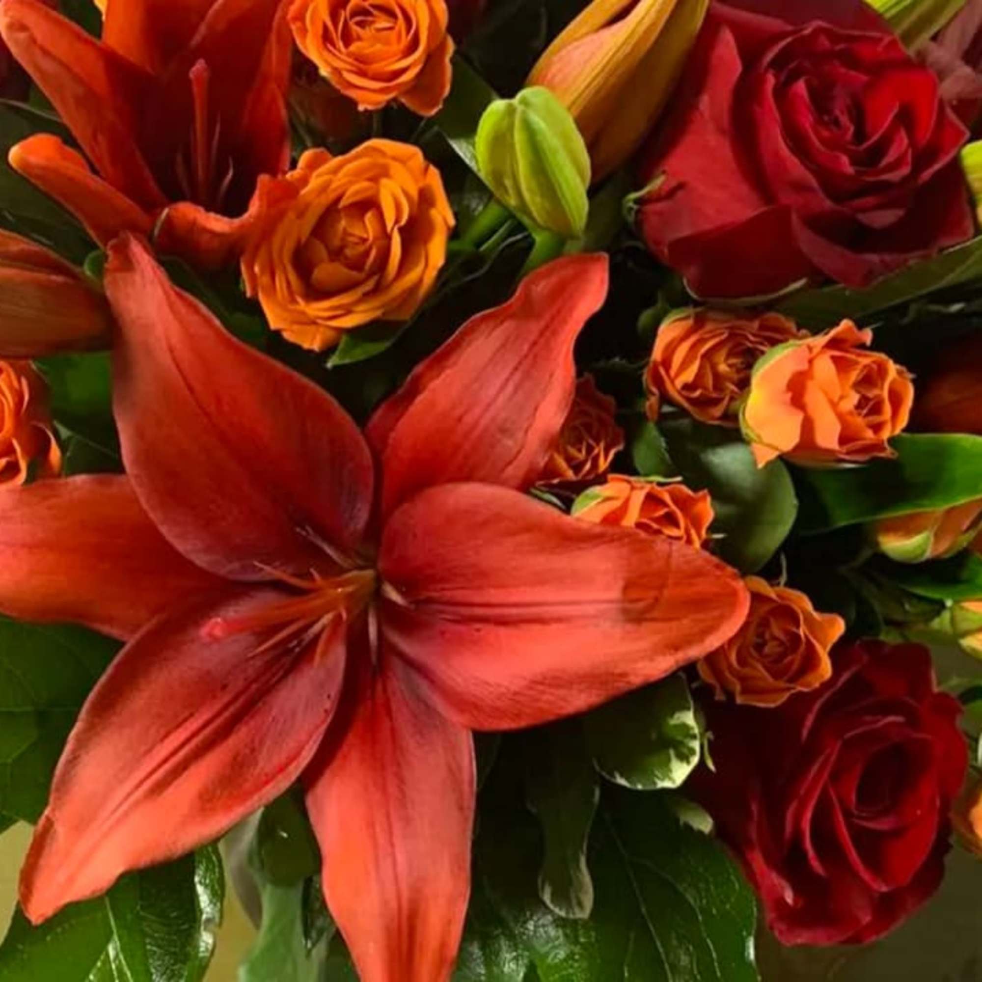 An elegant gathering vase filled with seasonal bright flowers such as asiatic