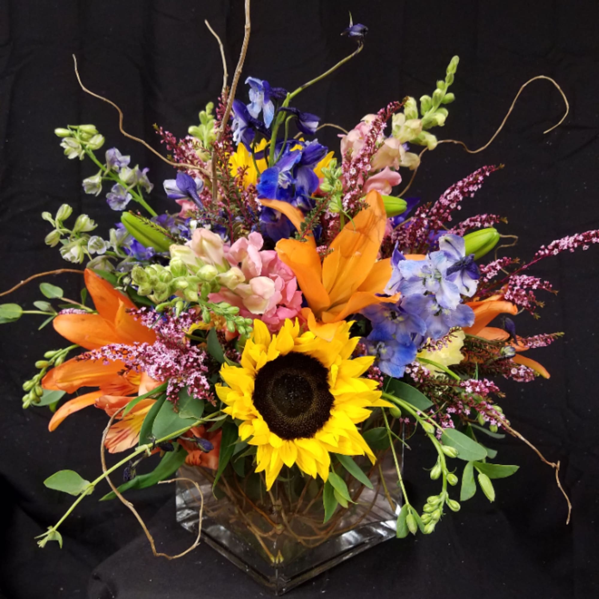 Glass cube all around mixed floral arrangement. 