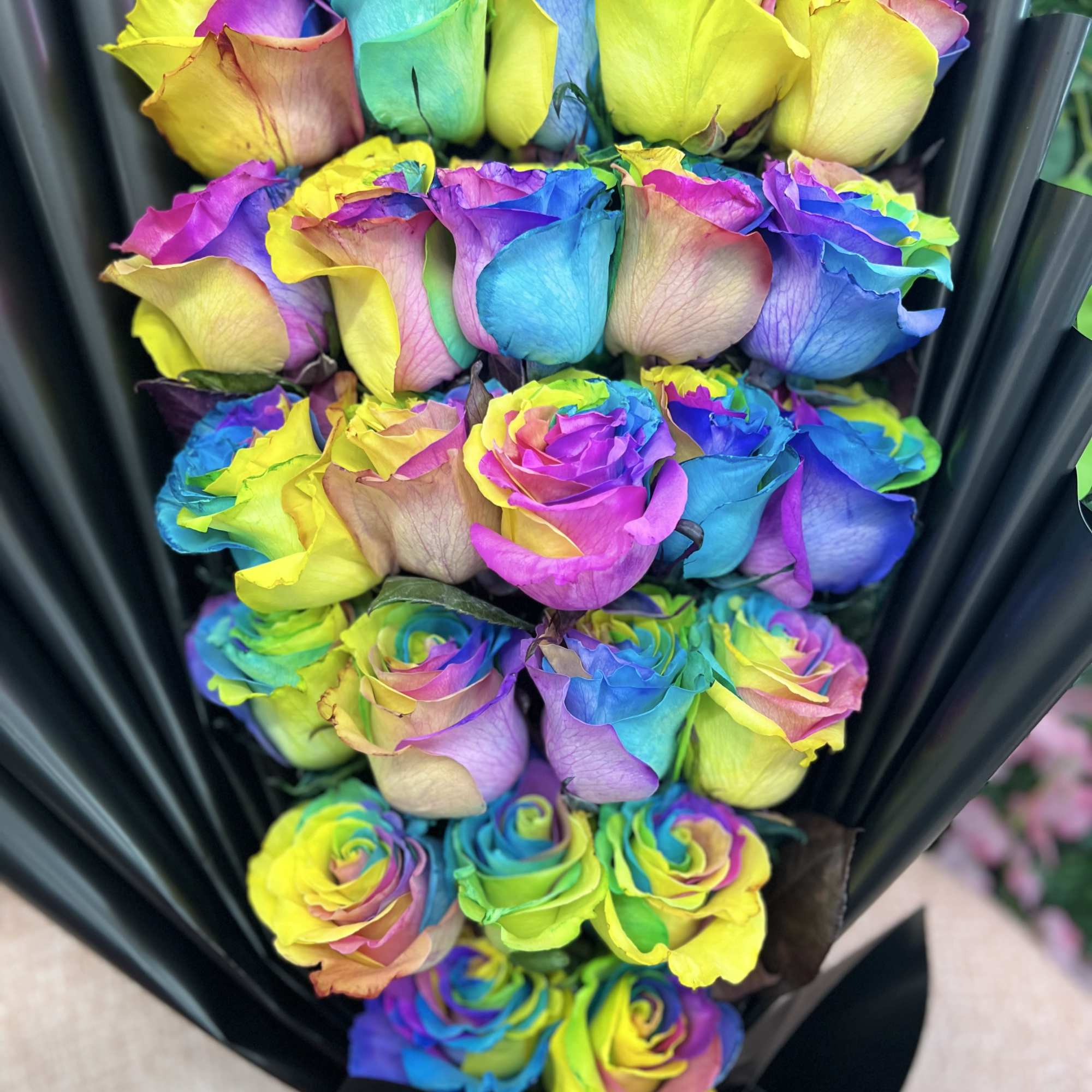 Brighten any moment with this vibrant Wrapped Rainbow Rose Bouquet. Each rose