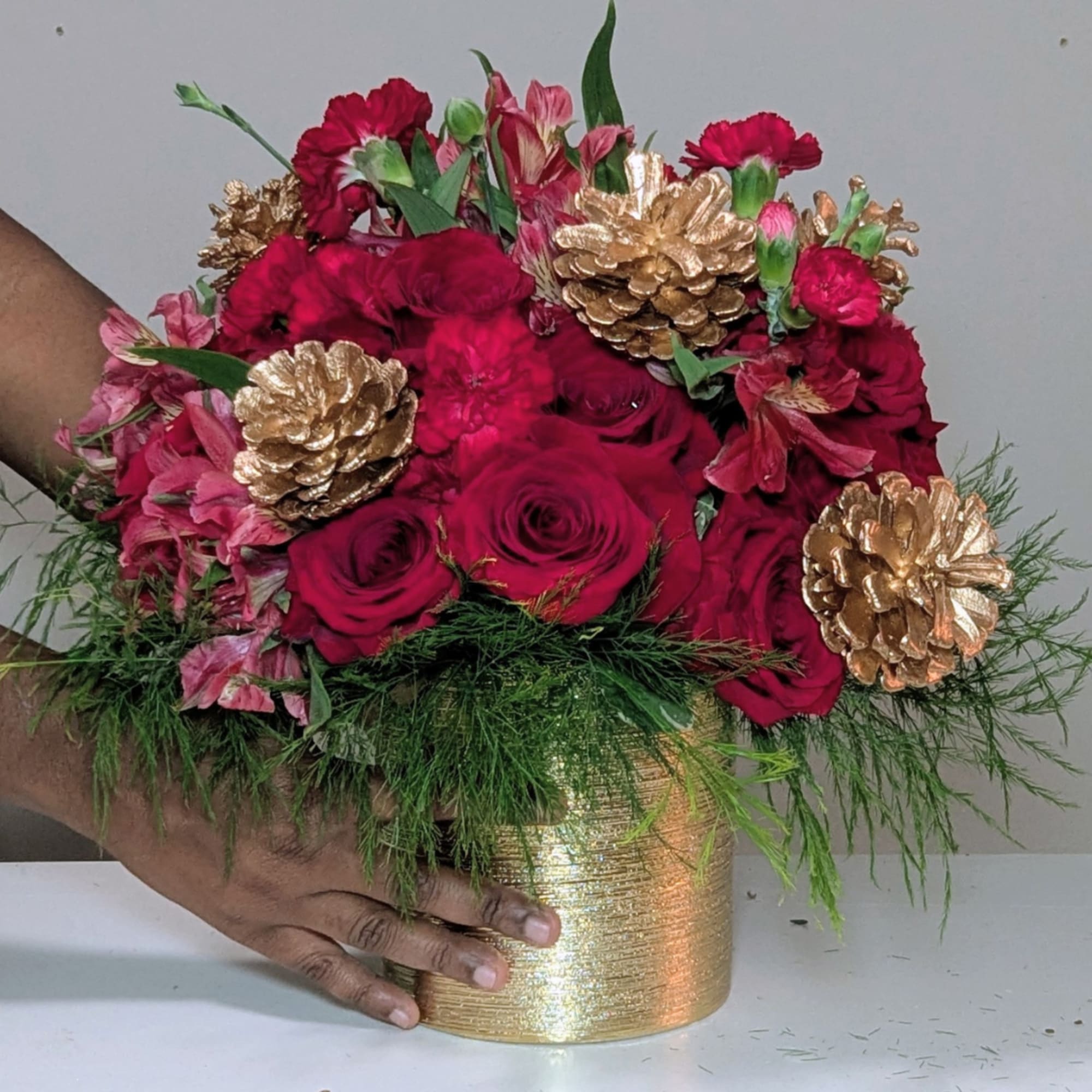 A timeless holiday arrangement that radiates warmth and sophistication. Featuring lush red