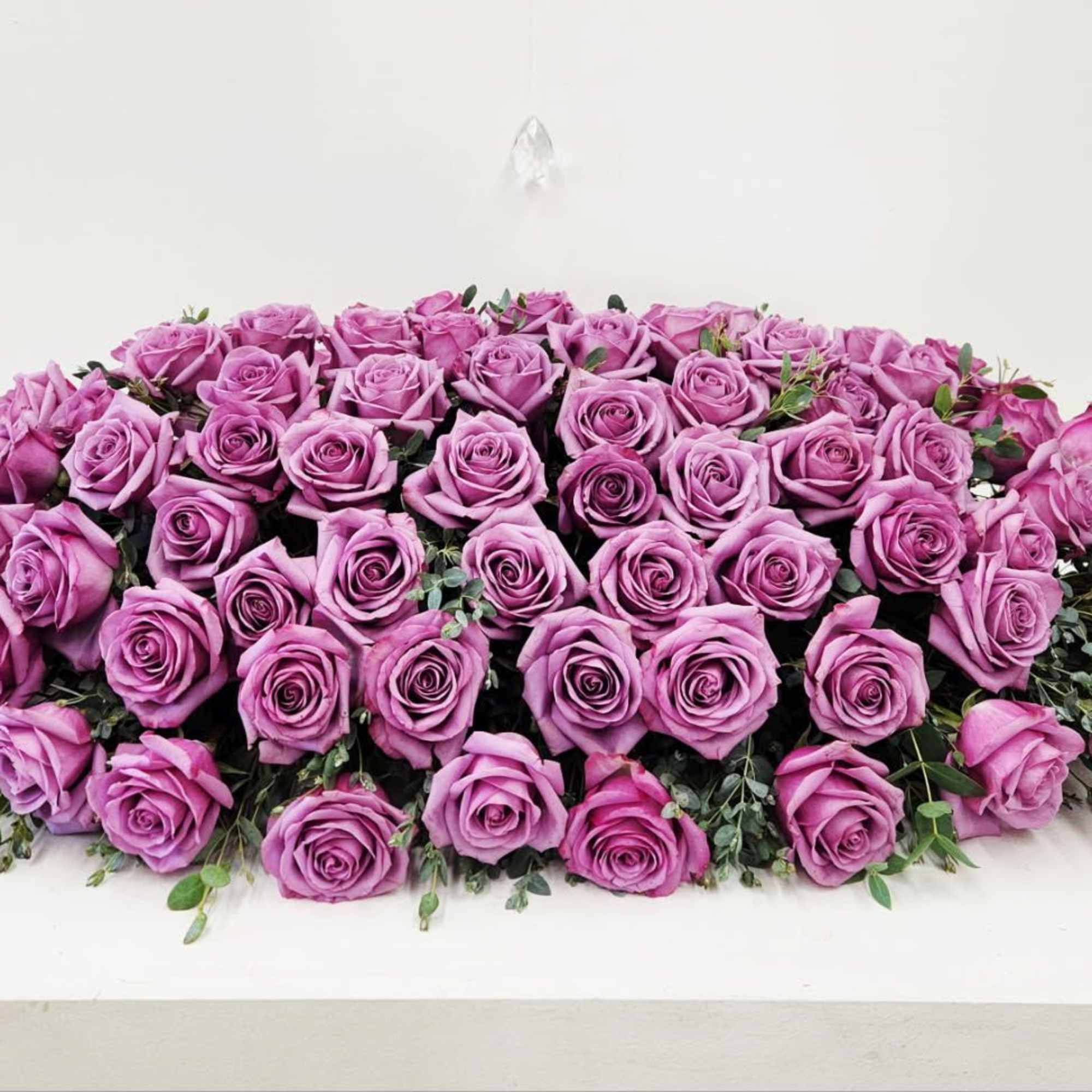 The Lavender Tribute Casket Spray offers a luxurious and elegant way to
