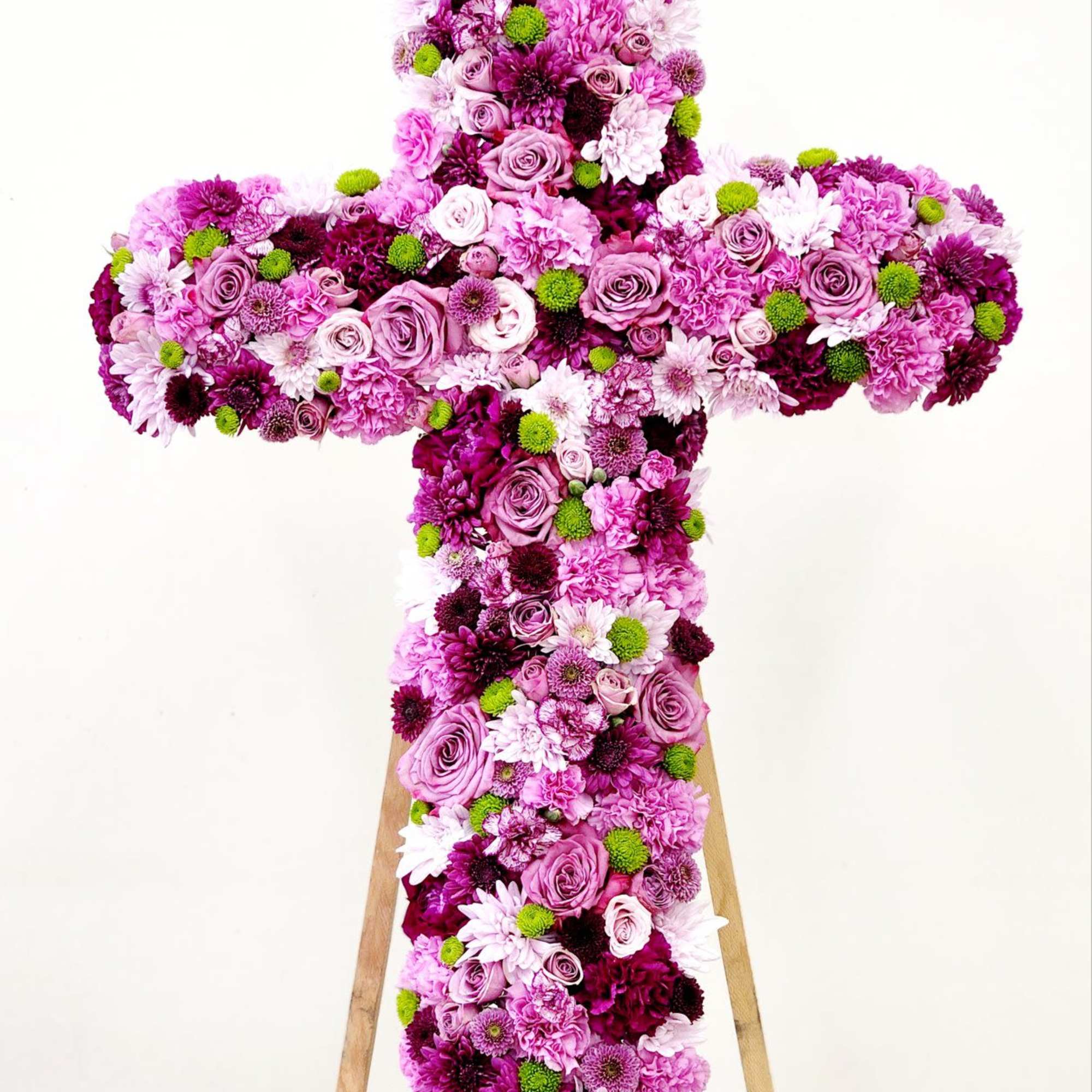 Celebrate faith and inner beauty with this elegant cross arrangement, crafted in