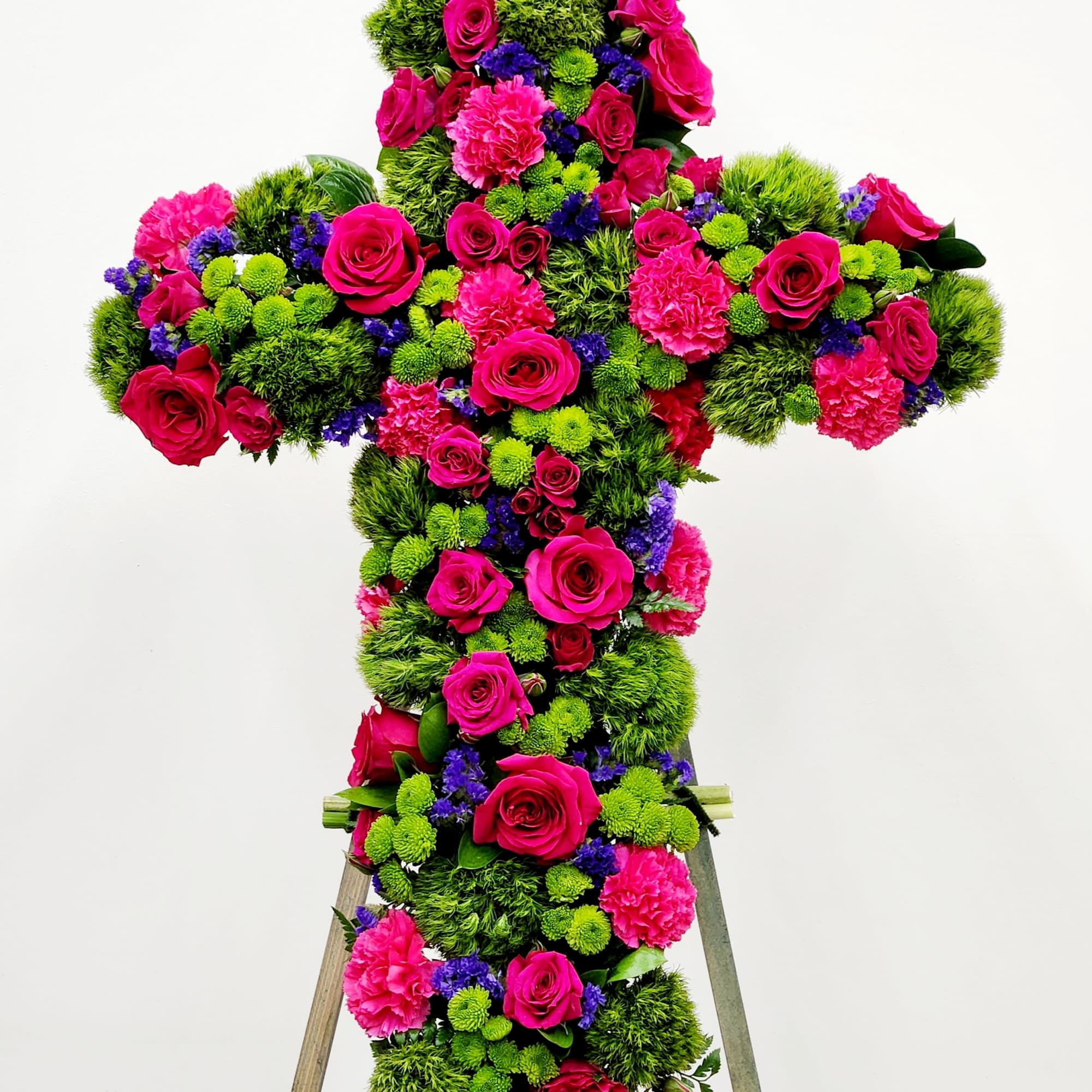 A timeless floral cross honoring cherished memories with grace and elegance. Lush