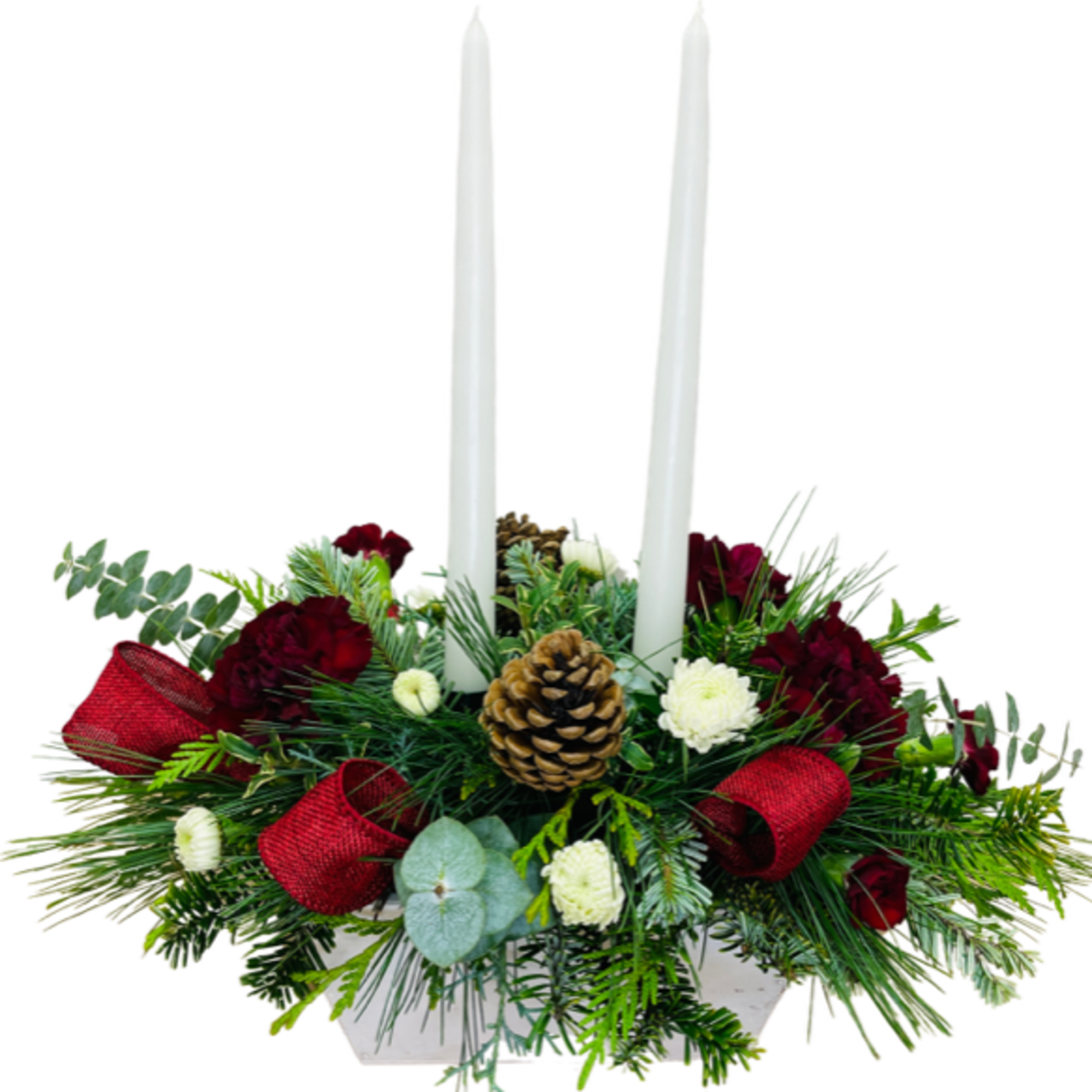 A Christmas centerpiece featuring 2 tapered candles, with seasonal greenery, pinecones and