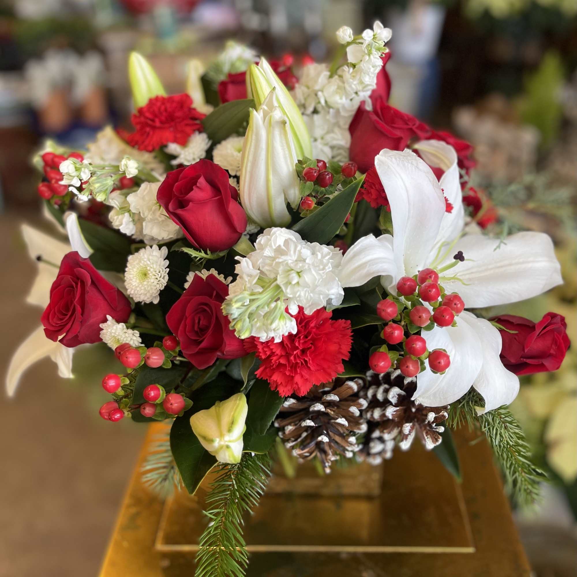 A beautiful 6&quot; glass cube container filled with traditional Christmas flowers &amp;