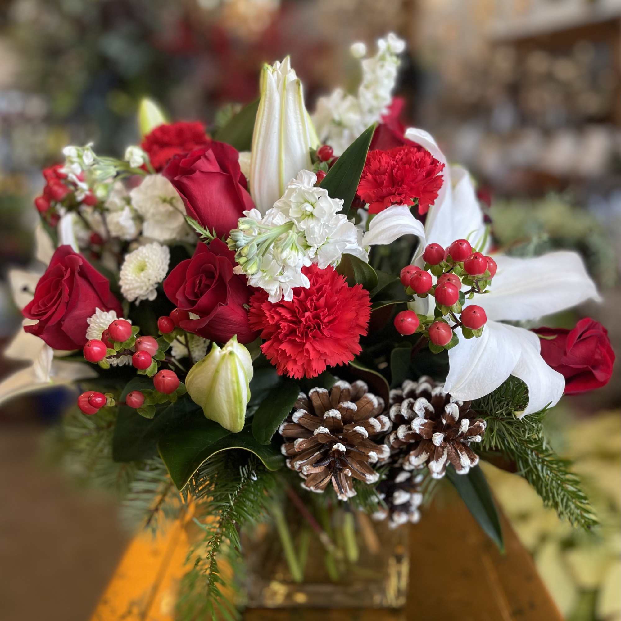 A beautiful 6&quot; glass cube container filled with traditional Christmas flowers &amp;