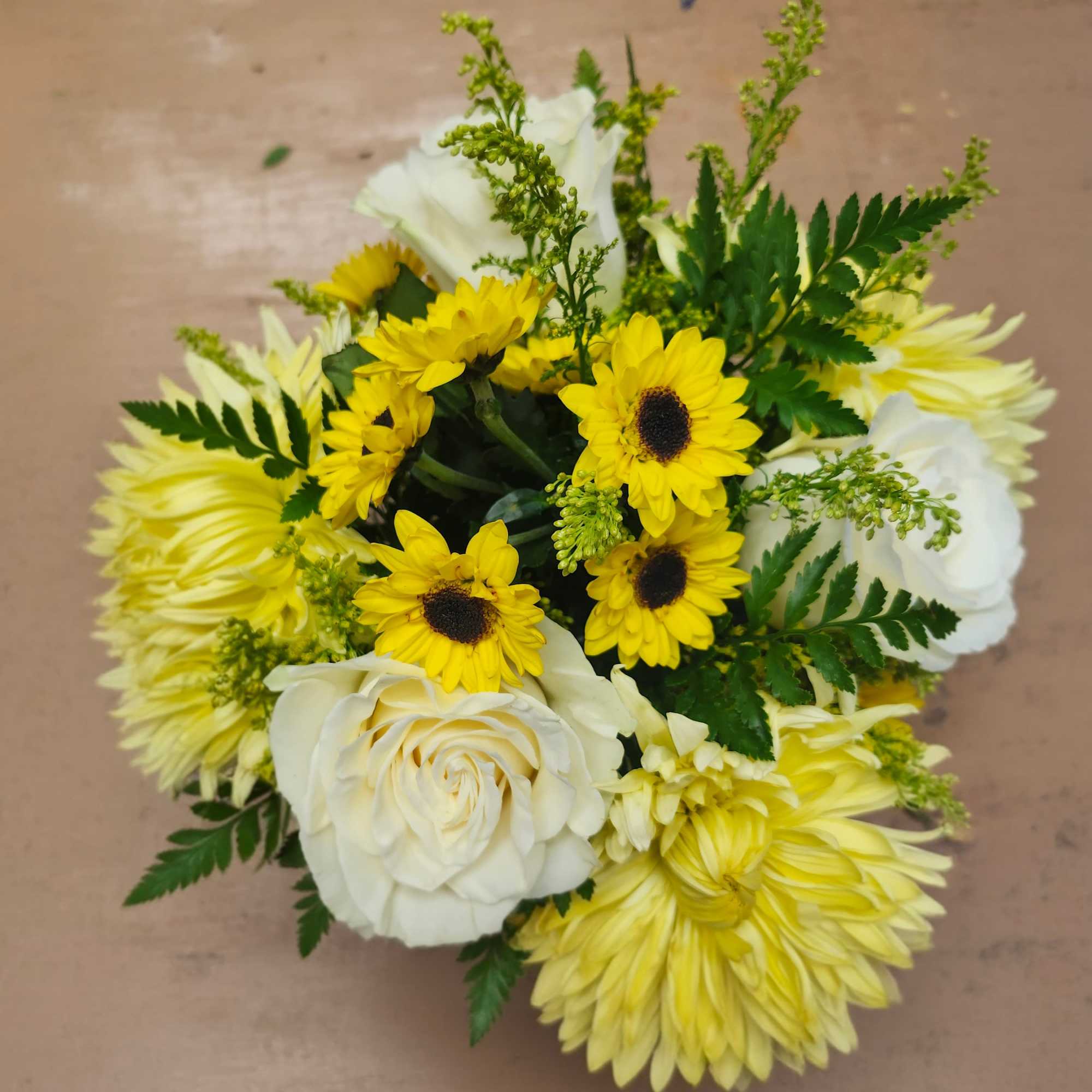 Bright and comforting, this cheerful arrangement blends soft white roses with sunny