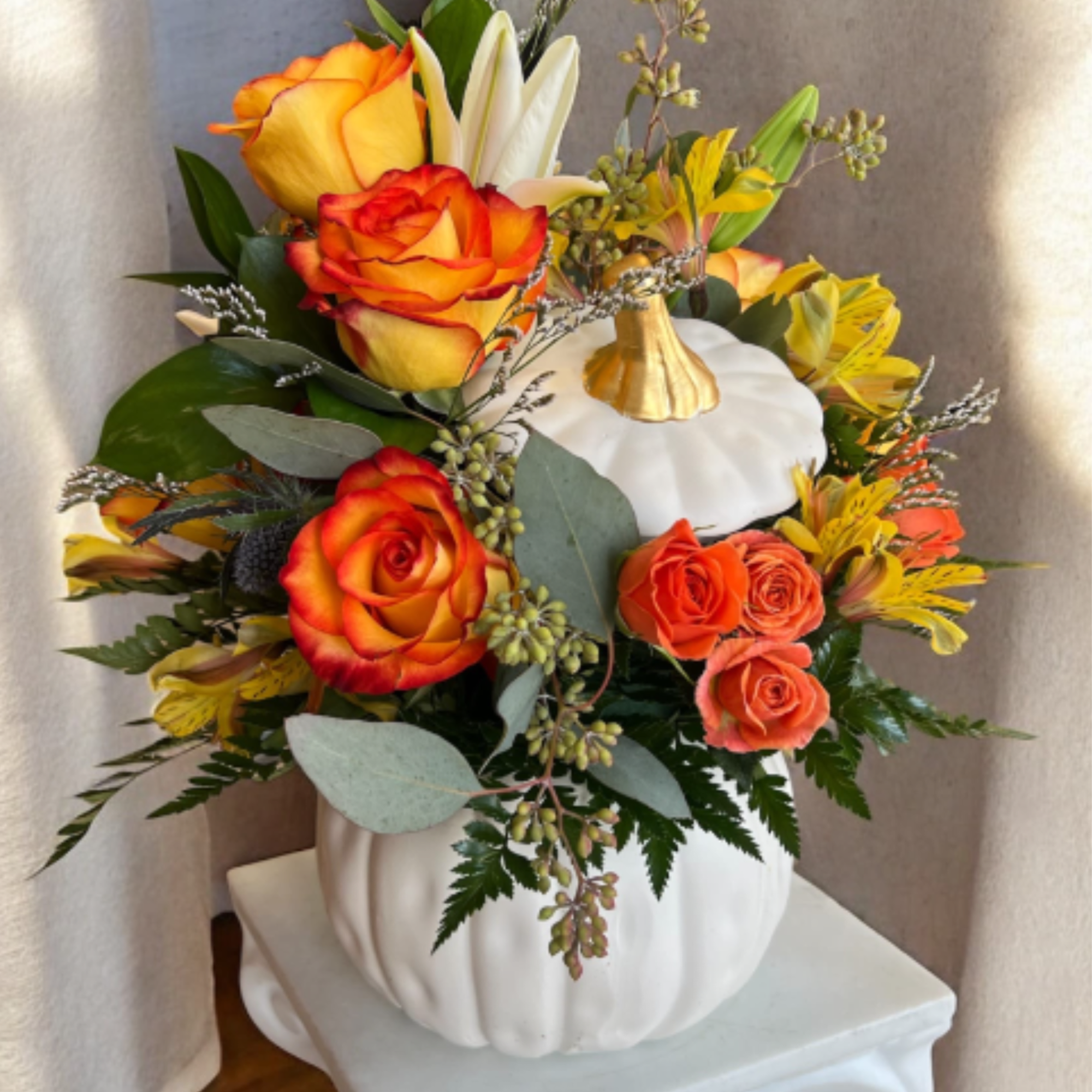 This beautiful floral arrangement features warm, vibrant tones perfect for the season.