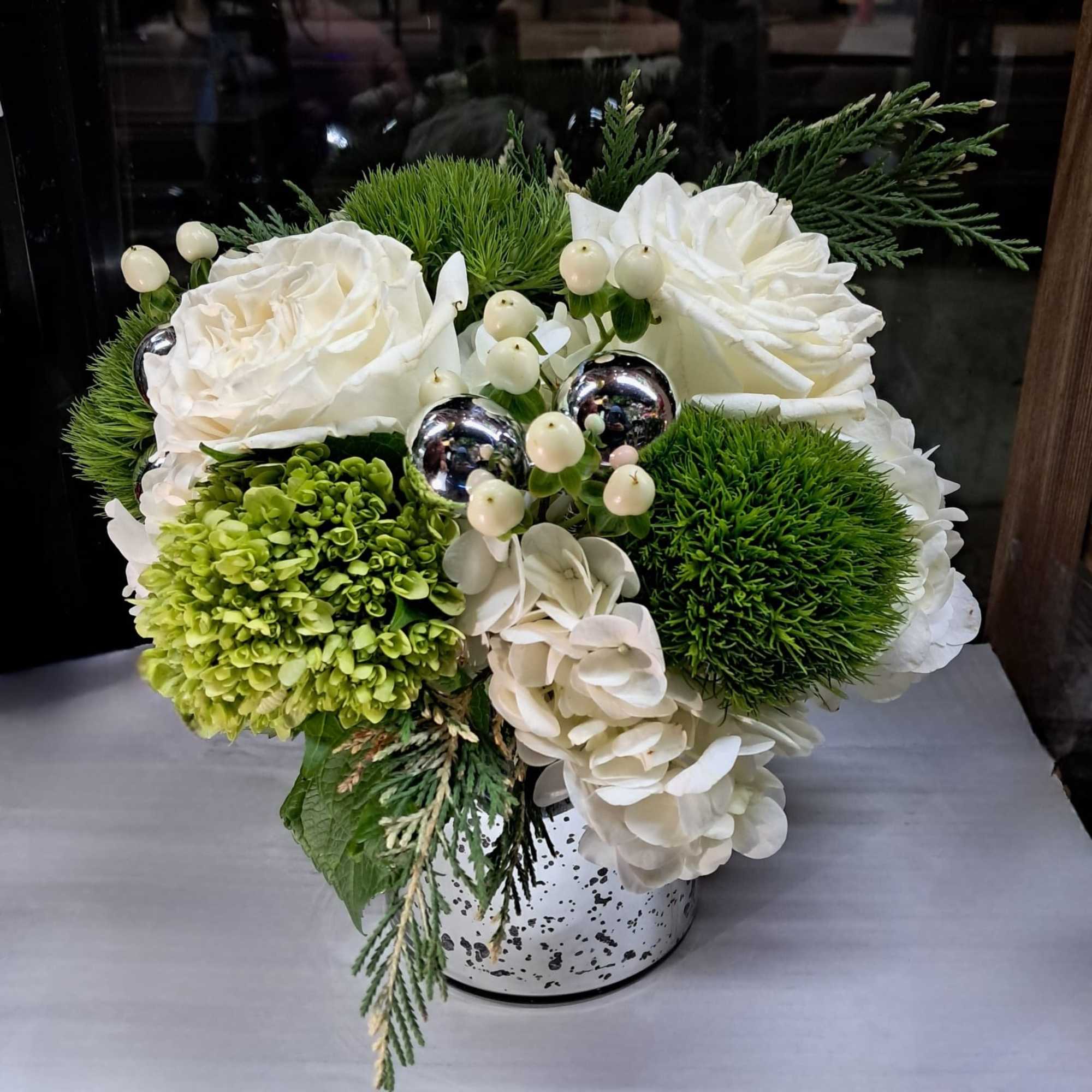 This beautiful arrangement has white roses, white and green hydrangeas, hypericums, small