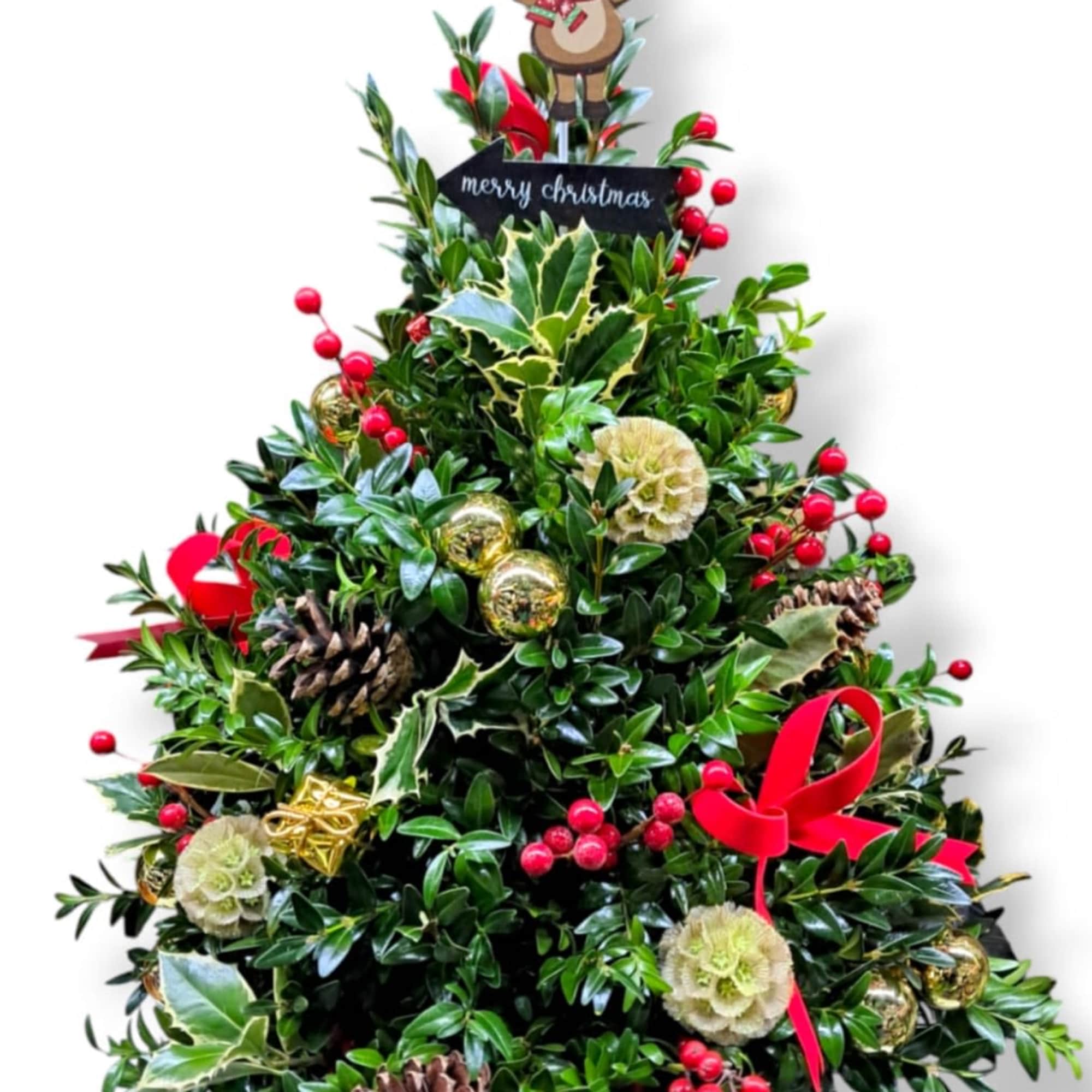 This festive mini tree is adorned with ornaments, bows, pinecones, holly, and