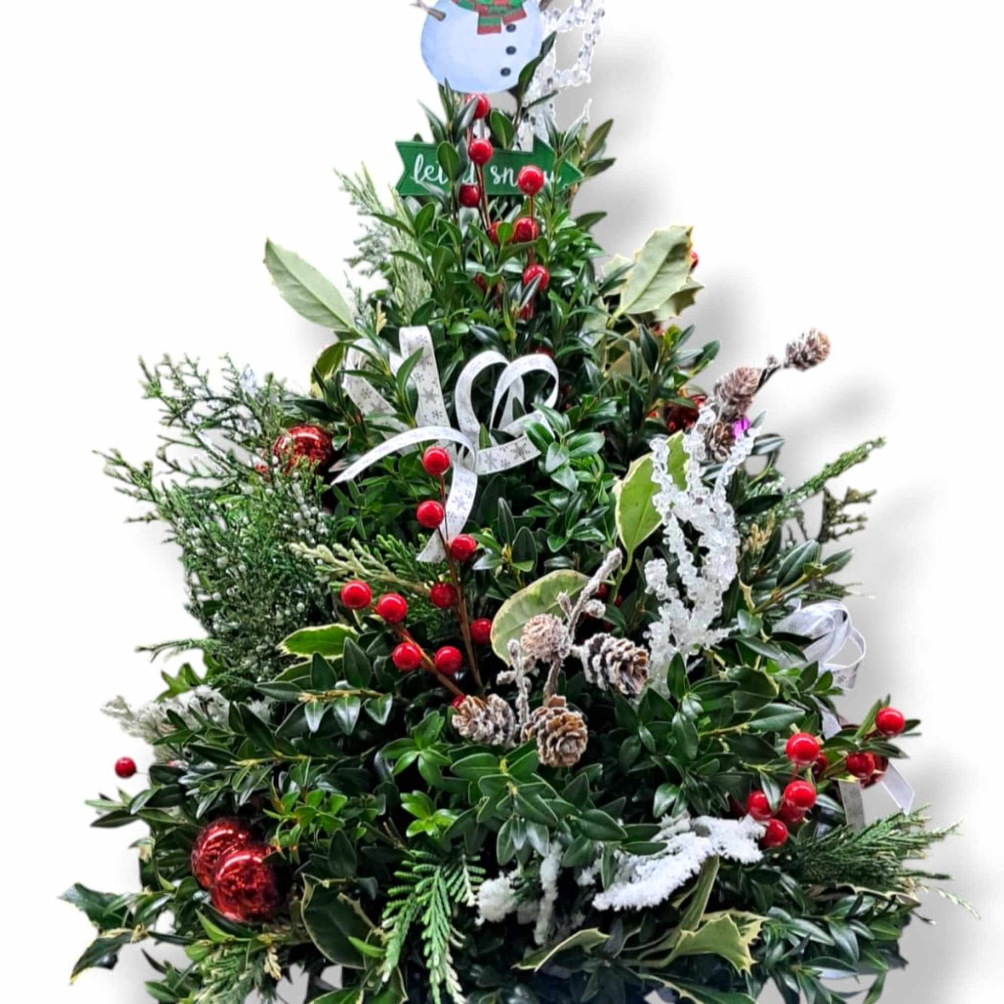This mini tree is adorned with artificial berries, holly, ornaments, bows and