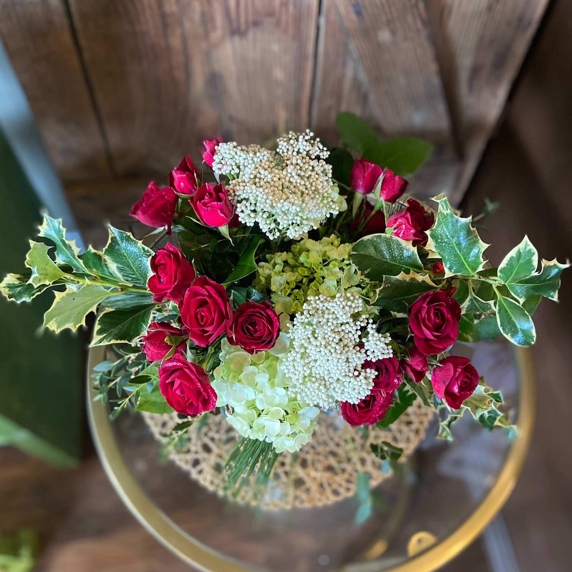 Delicate spray roses with hydrangeas and festive filler.  Adorned with evergreens
