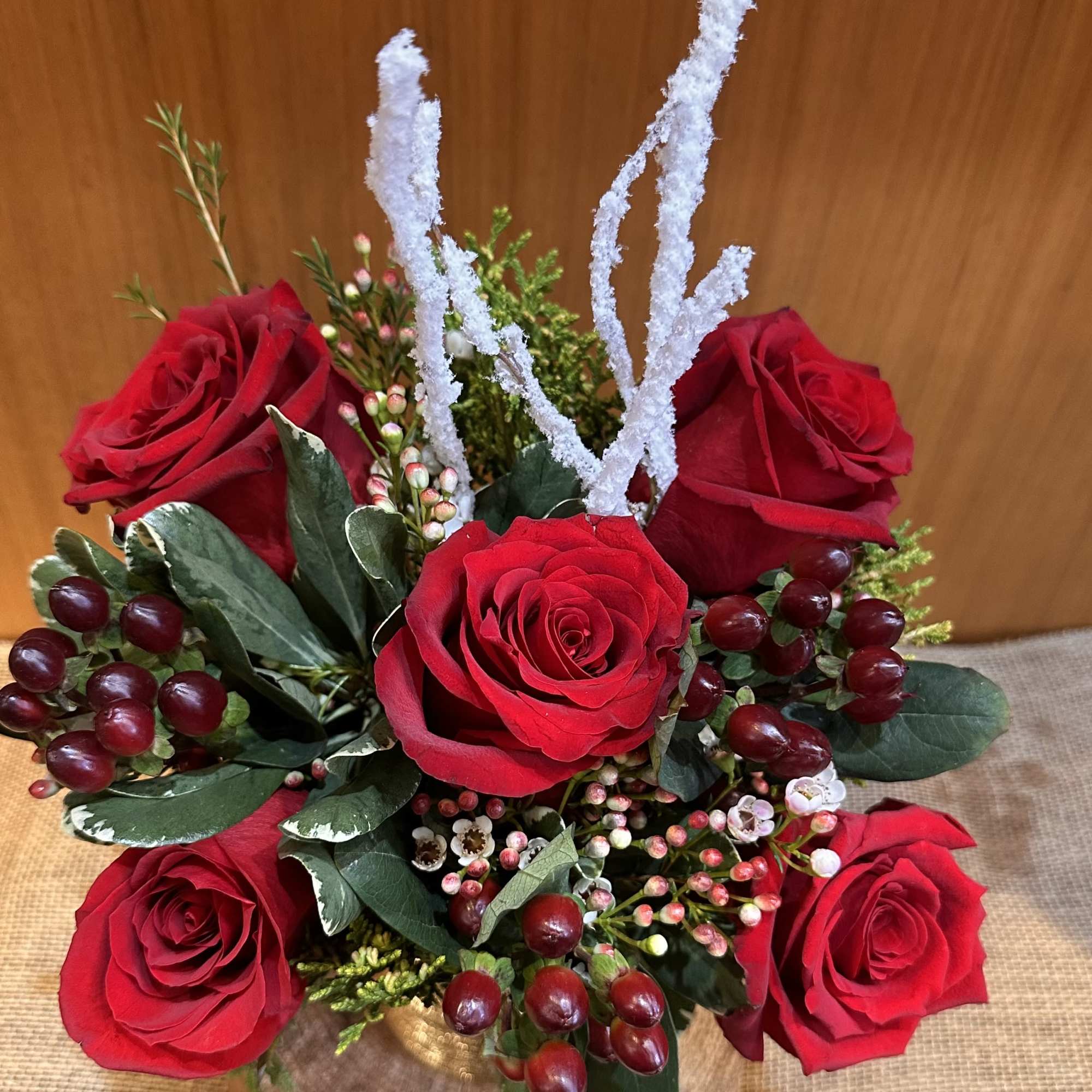 Premium quality red rose arrangement with Christmas season greenery. Arranged in a