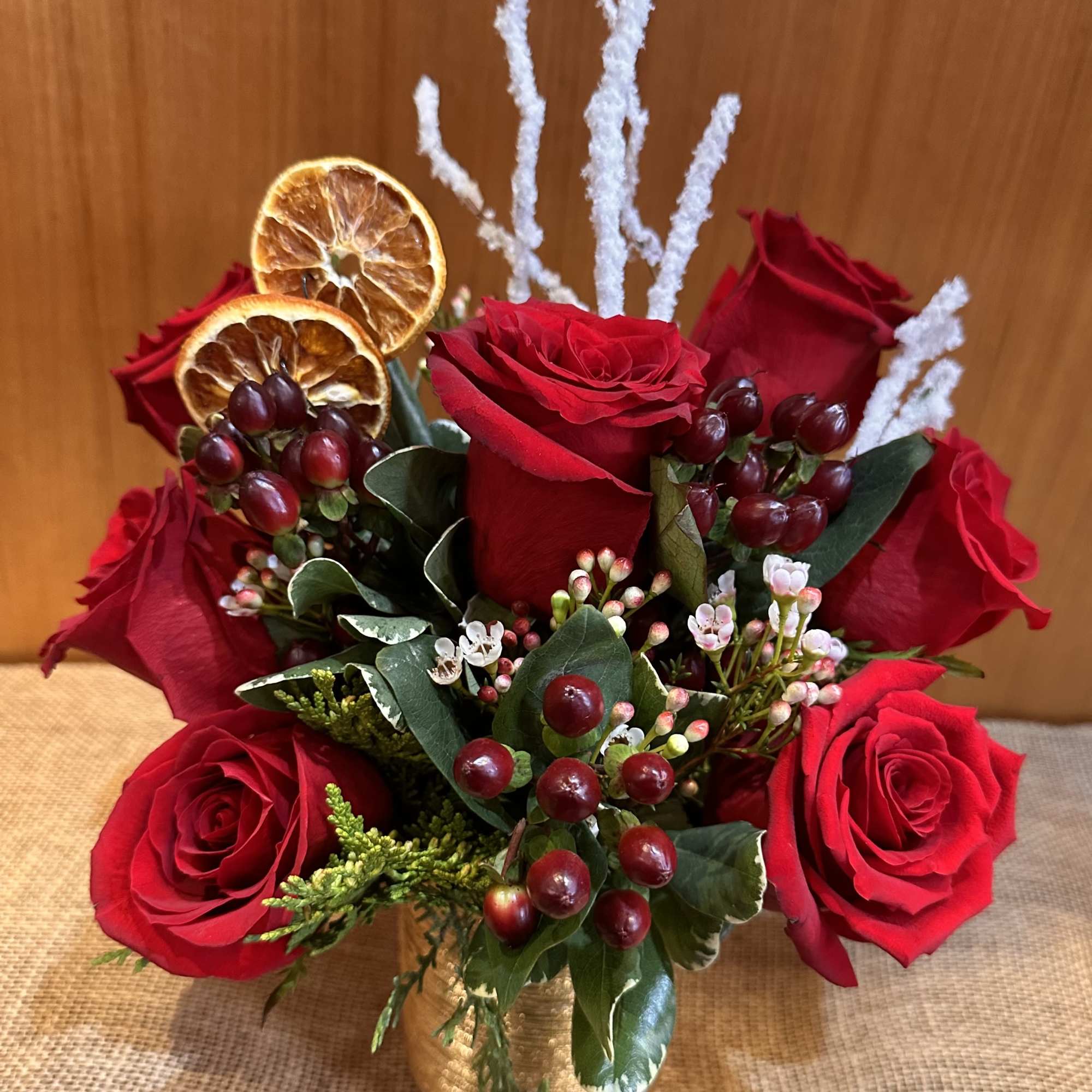 Premium quality red rose arrangement with Christmas season greenery. Arranged in a