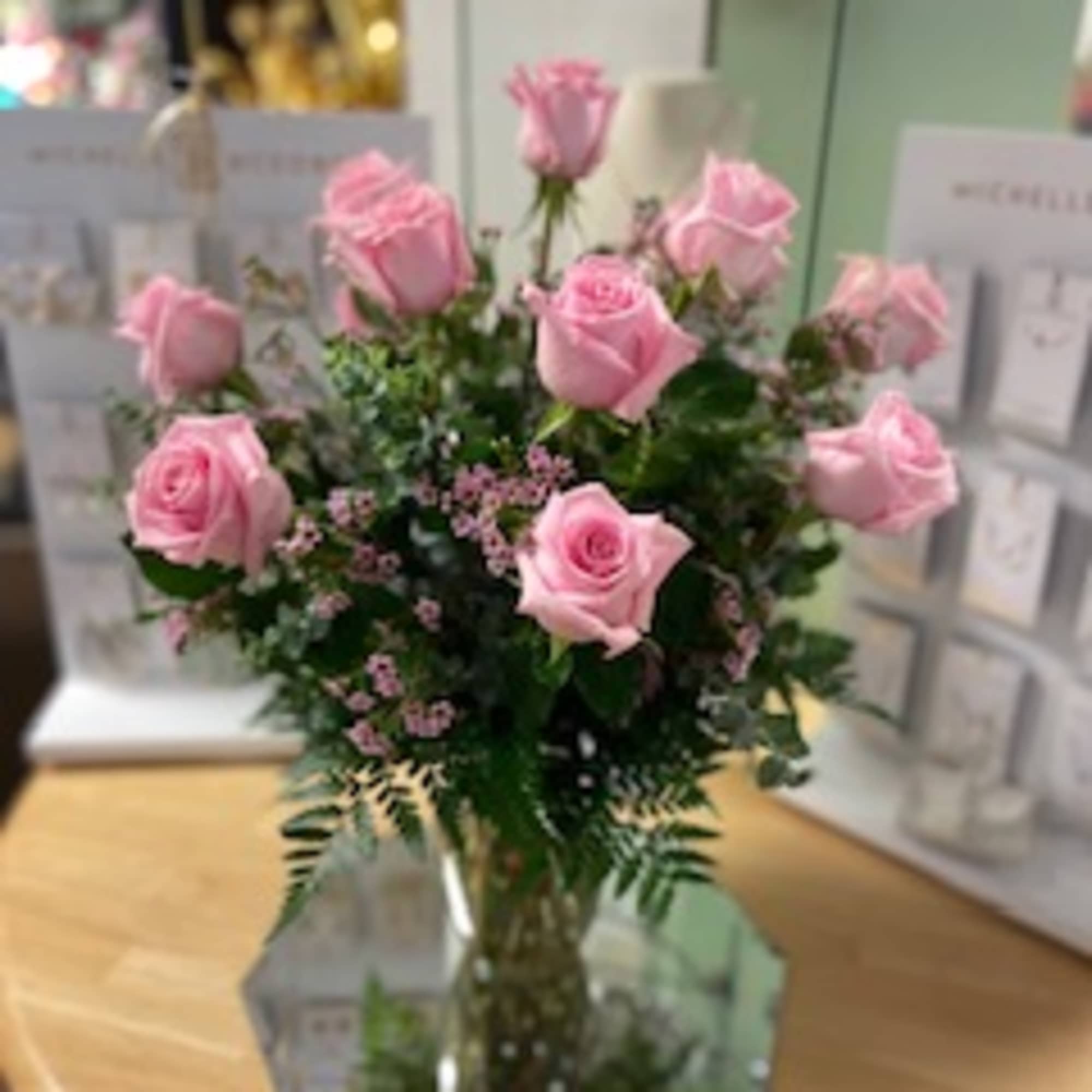 One Dozen Beautifully Arranged Pink Roses In Glass Vase With Fillers And