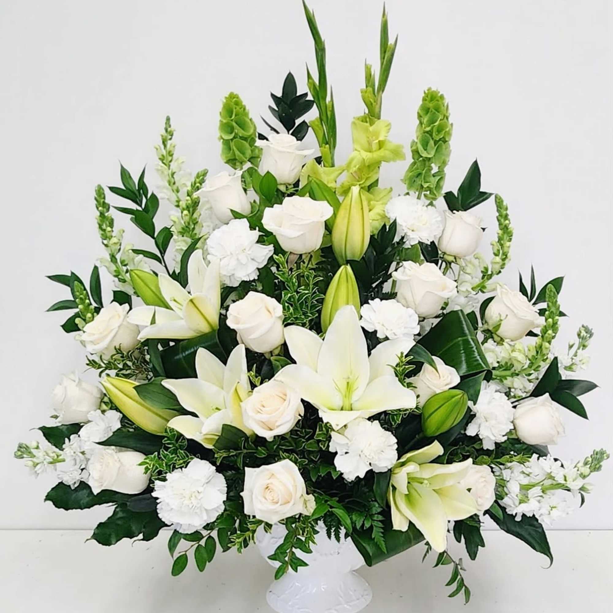 This elegant one-sided altar arrangement showcases graceful white lilies paired with lush
