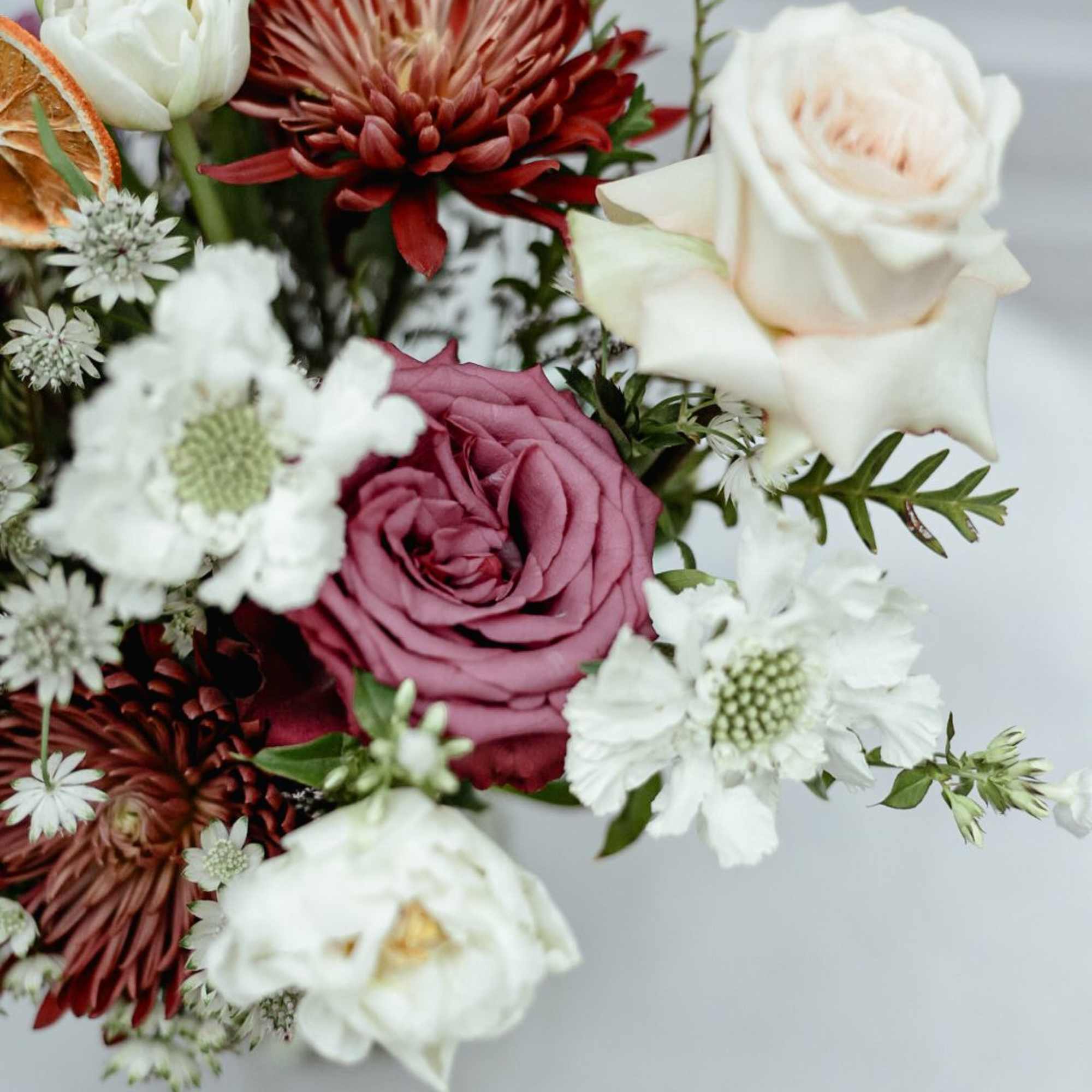 A lovely red and white arrangement of roses, astrantia, double tulips, and