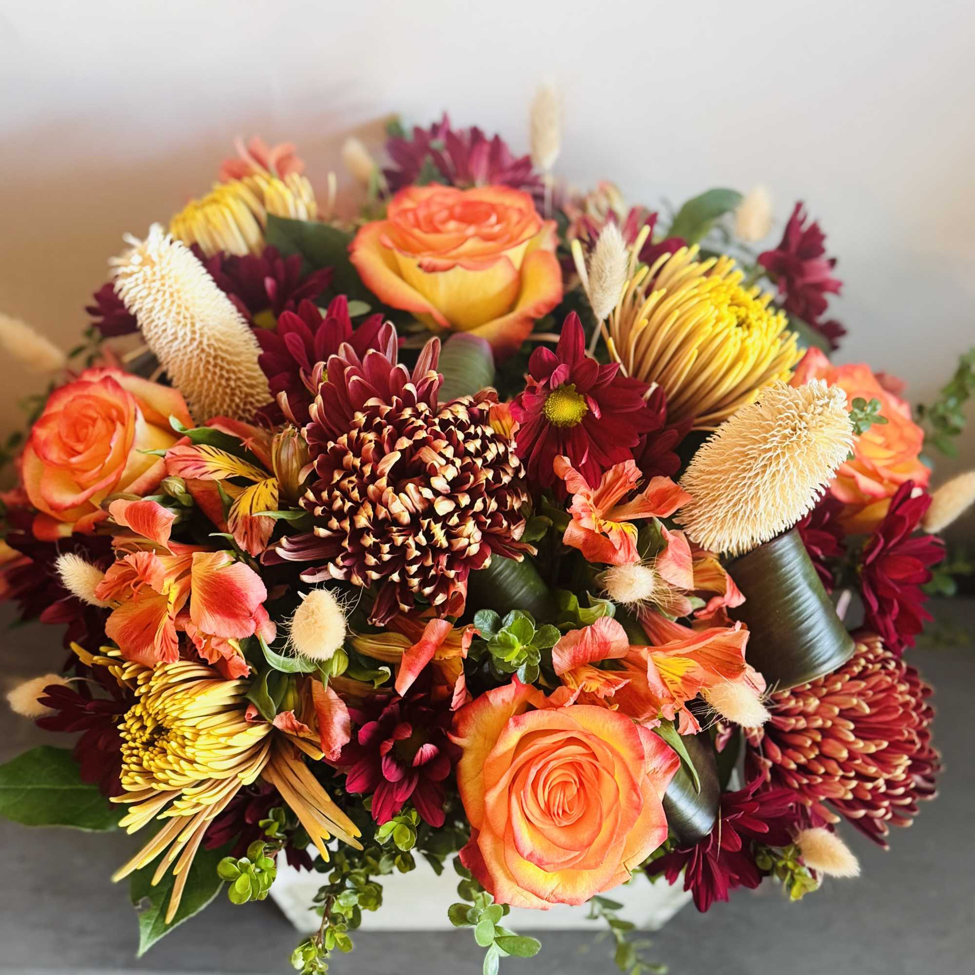 A fall inspired arrangement with lilies, sunflowers, roses, stem roses, hypericum berries