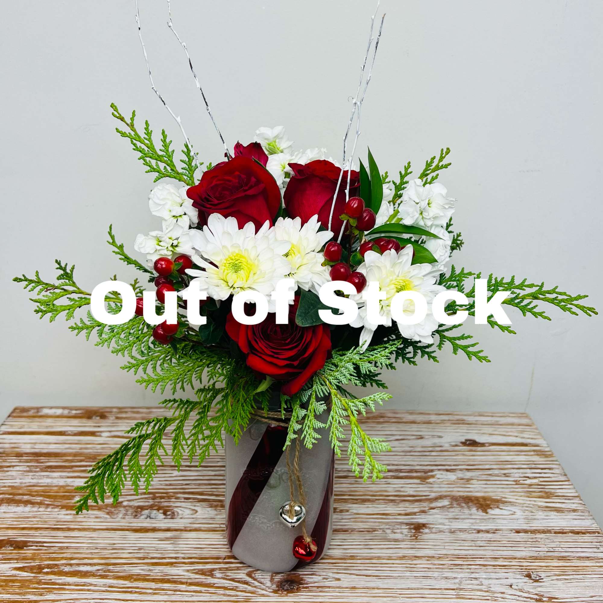 A candy cane mason jar vase with jingle bells filled with festive