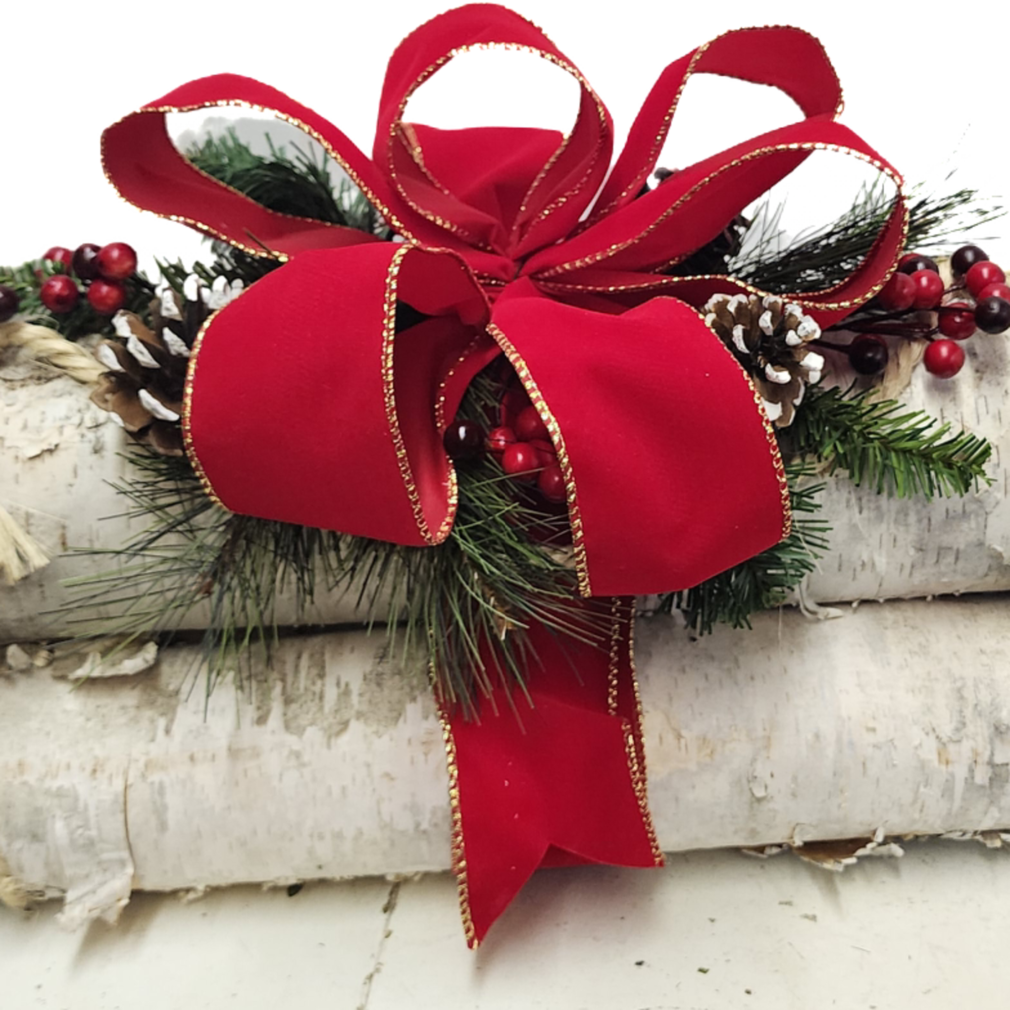 A trio bundle of birch logs tied and adorned with red velvet