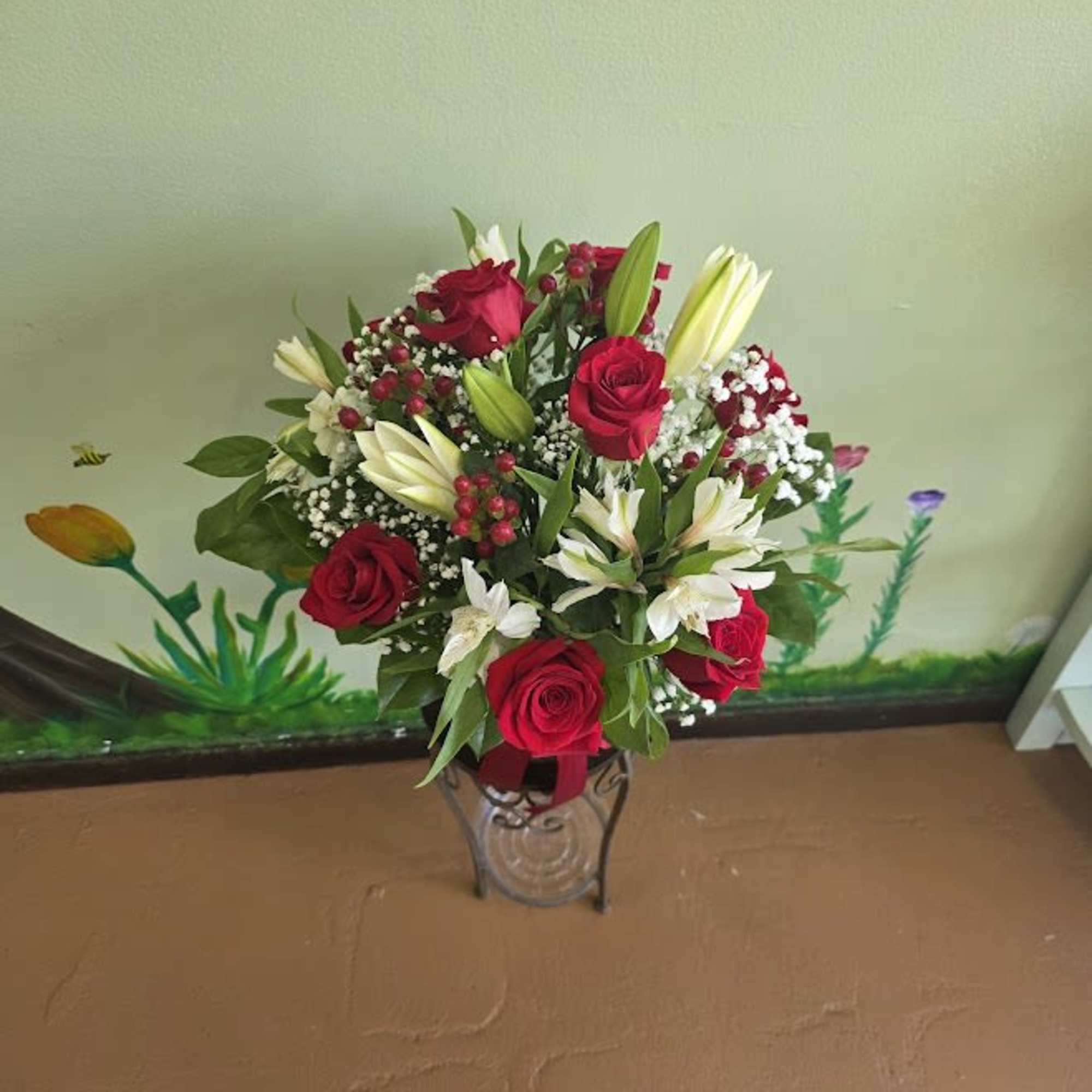 A stunning arrangement of deep red roses, white alstromeria, delicate white lilies