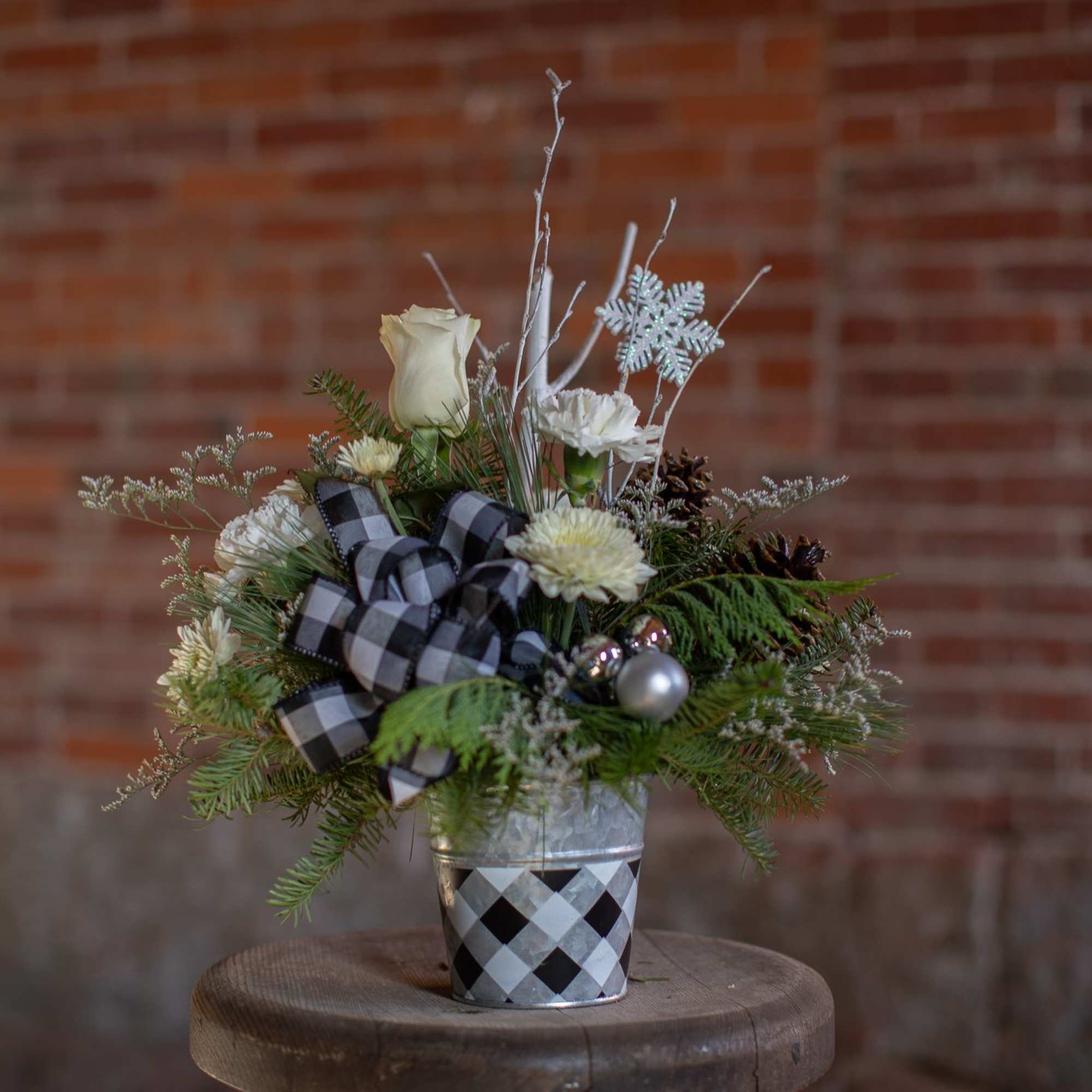 A winter buffalo plaid themed arrangement for the season. A printed tin