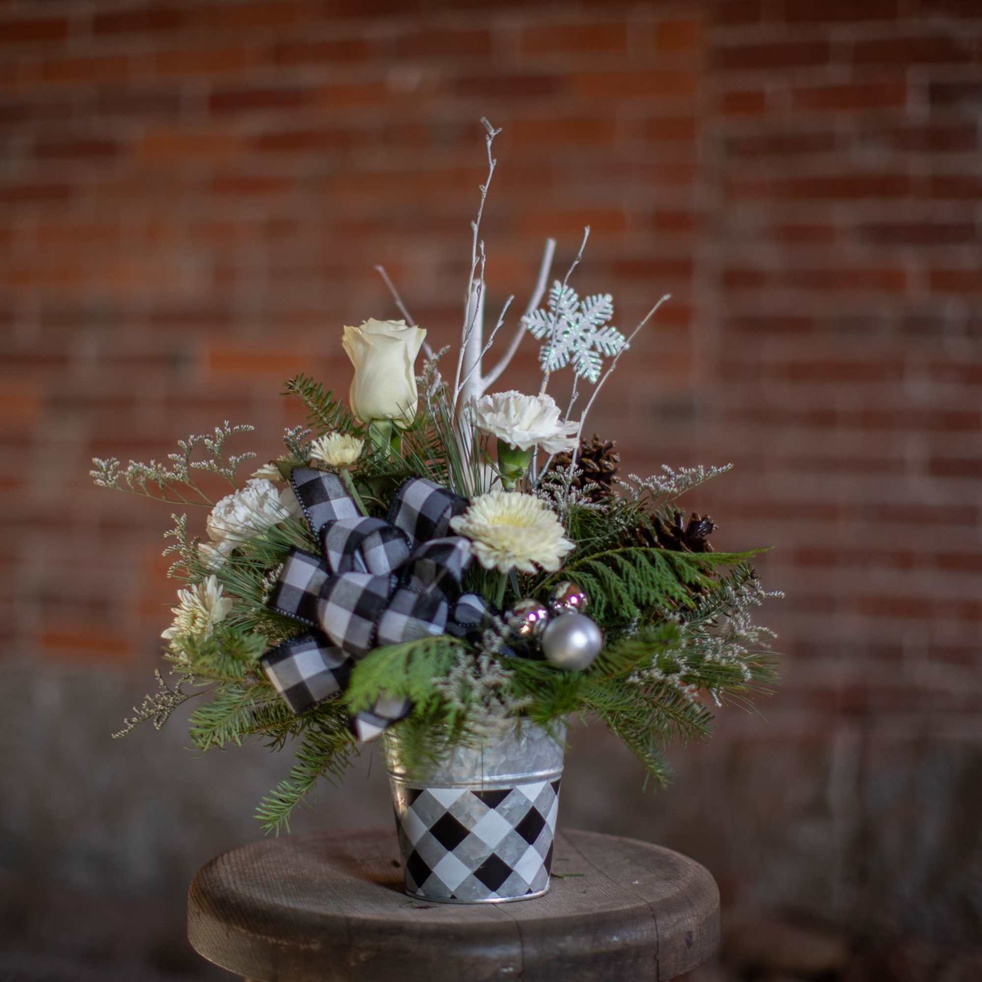 A winter buffalo plaid themed arrangement for the season. A printed tin