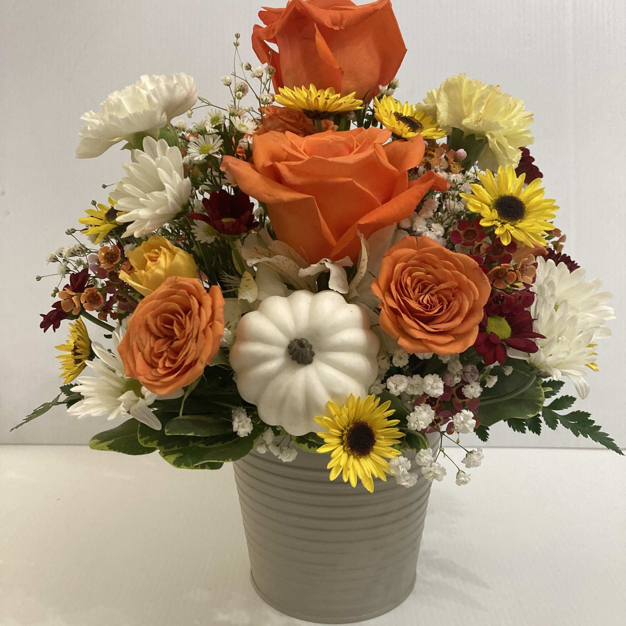 Beautiful arrangement in colorful metal container with Roses, Carnations, Daisies, spray roses